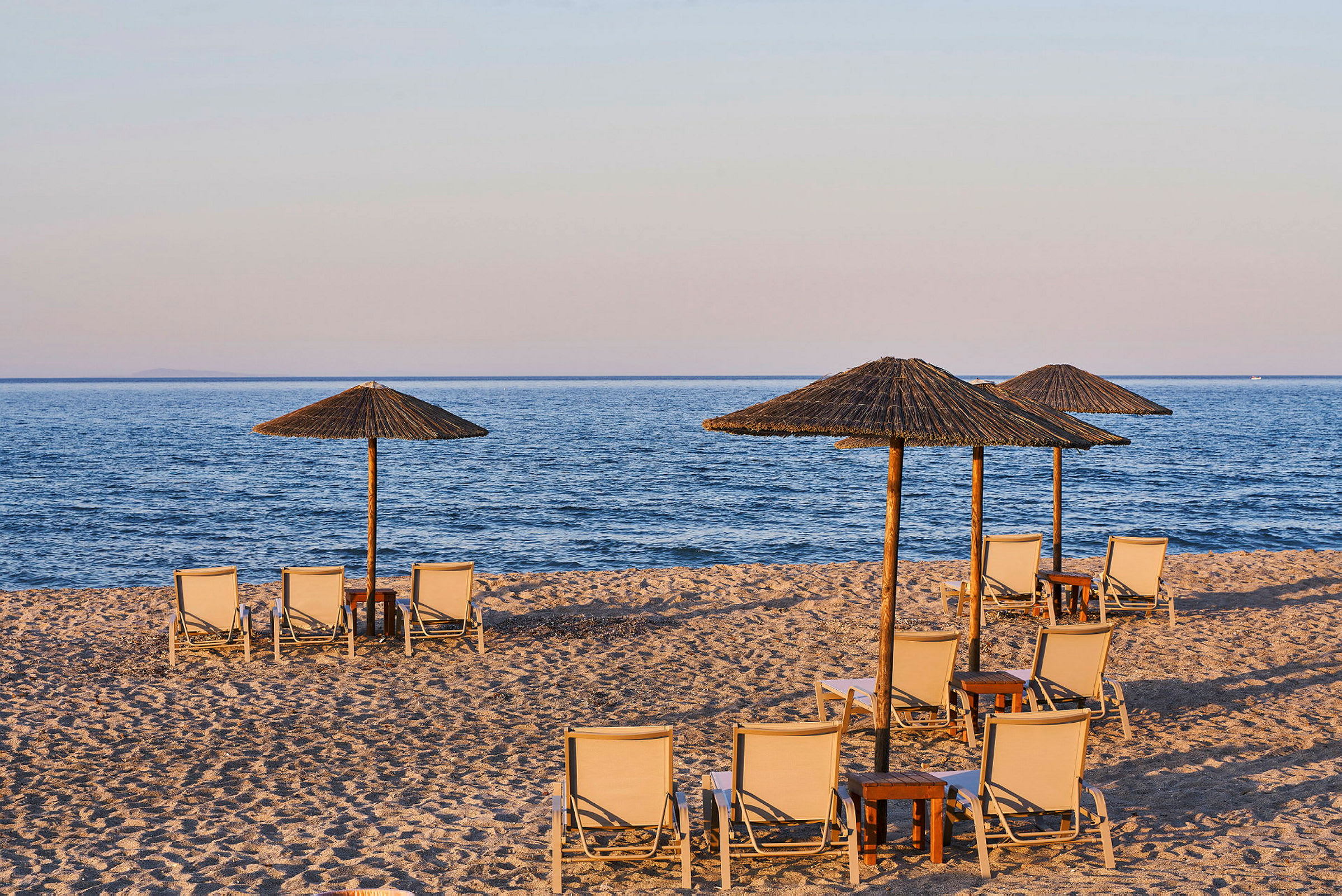 Strand med solstolar och parasoller vid vattnet. (AI-genererad text)