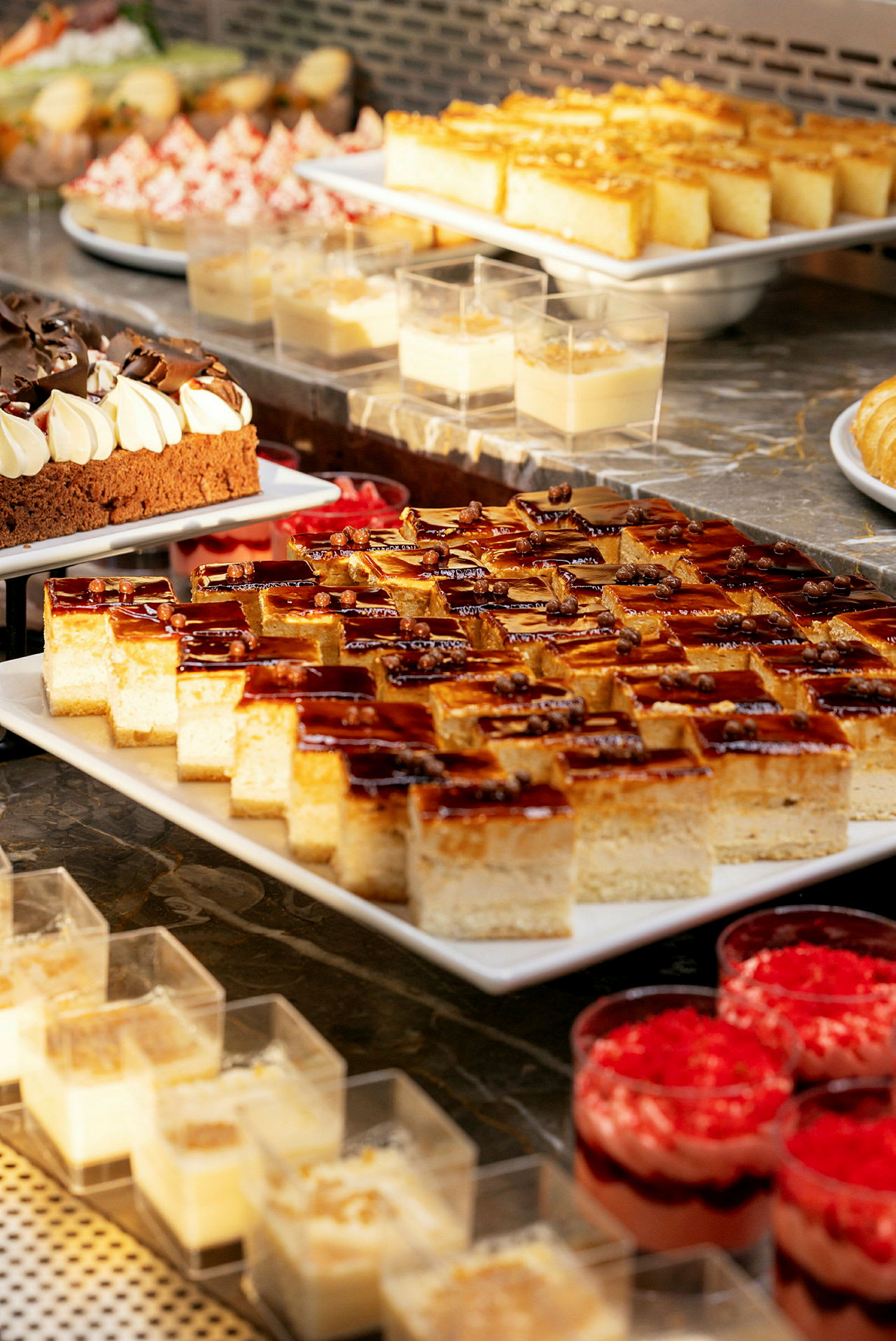 Ett urval av desserter arrangerade på ett buffébord. (AI-genererad text)