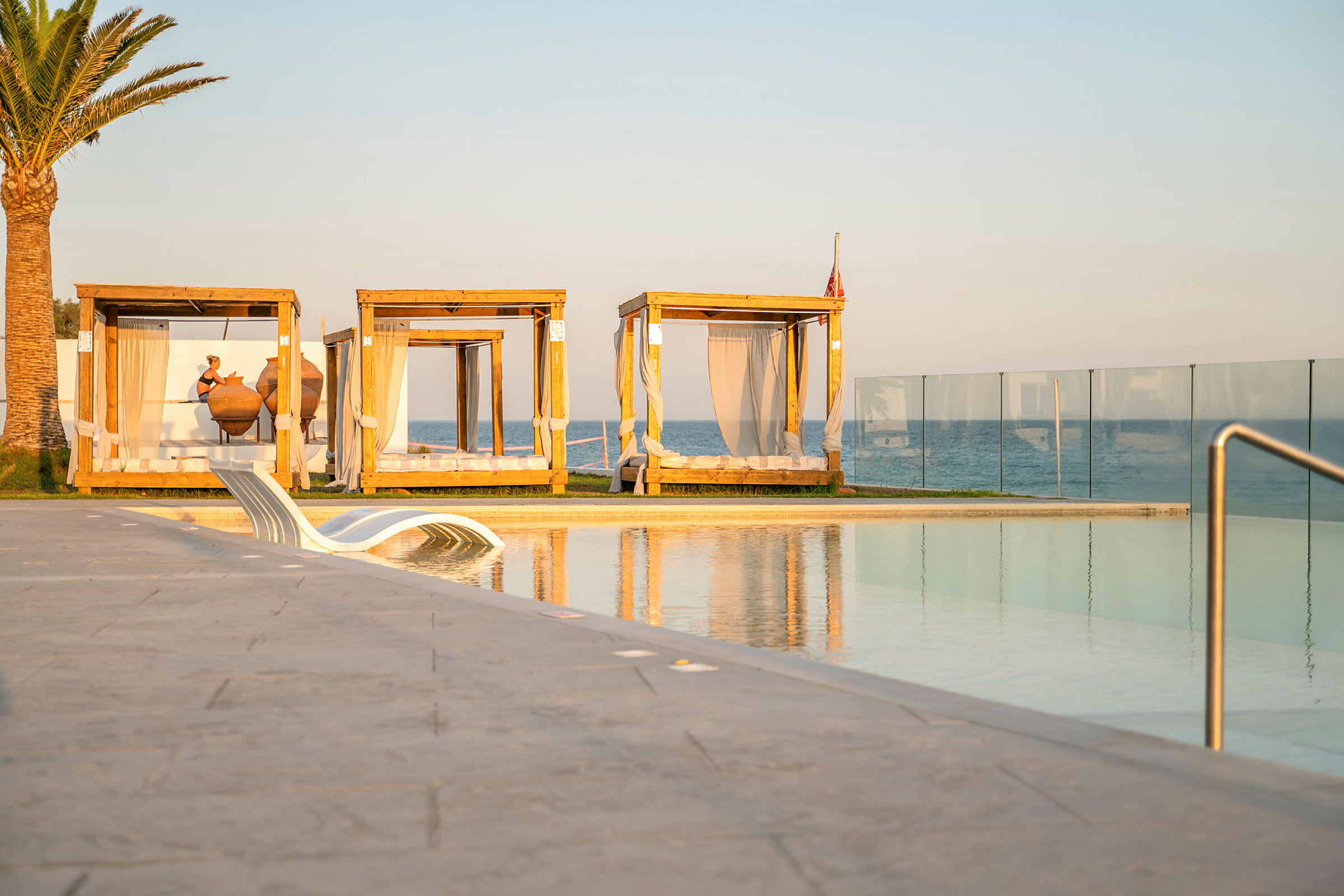 Strandnära poolområde med solbäddar och havsutsikt. (AI-genererad text)