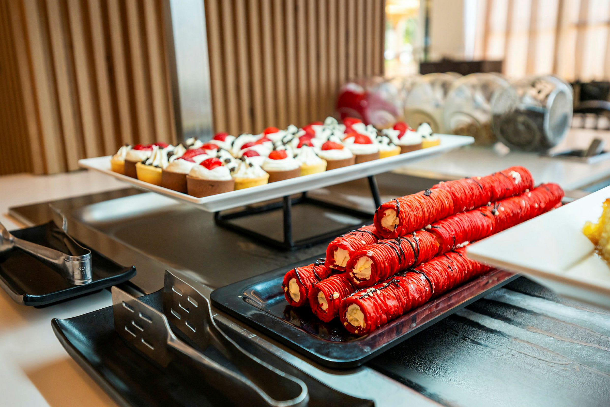 Ett dessertbord med en tallrik små bakverk och rullar fyllda med kräm. (AI-genererad text)