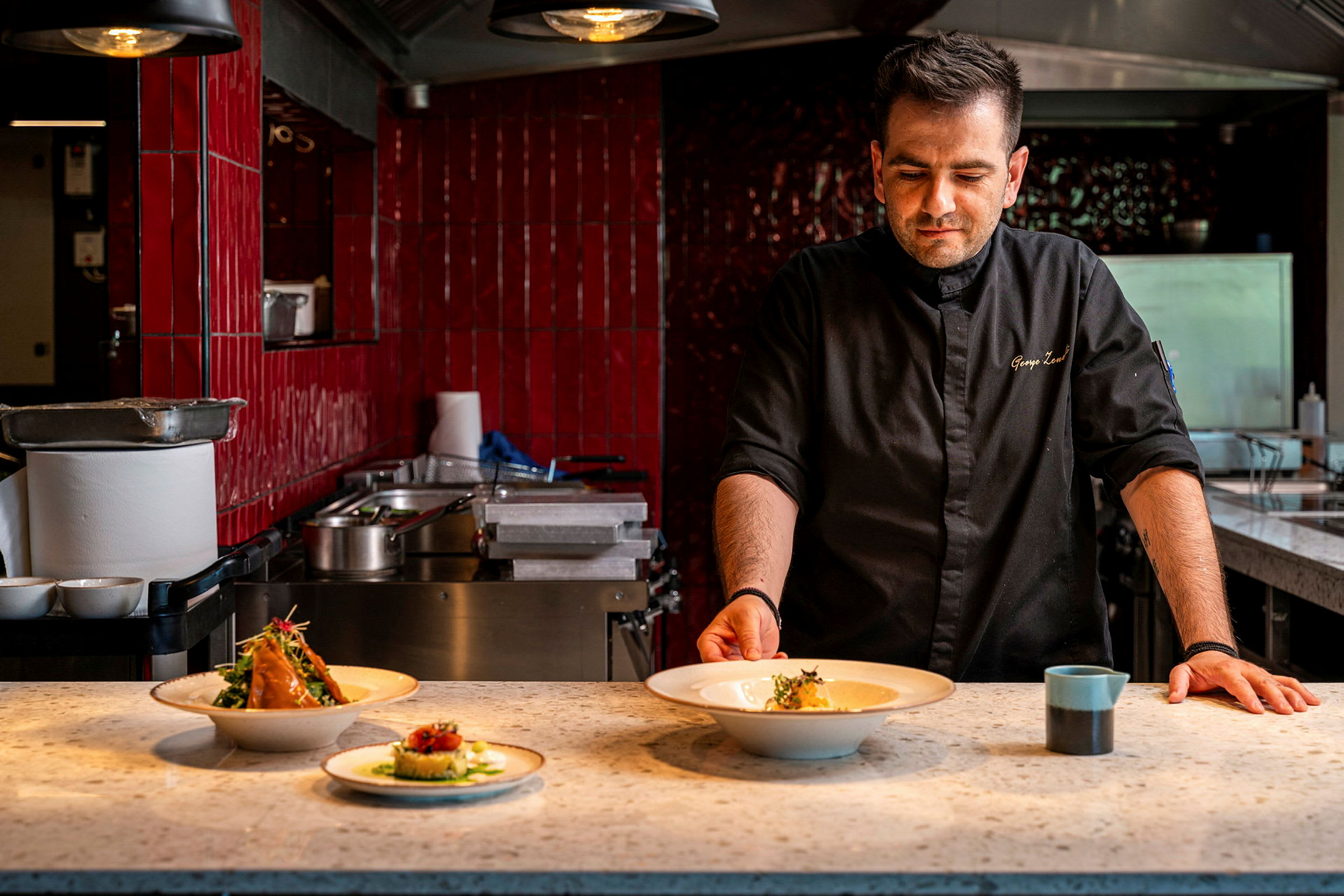 En serveringsyta med tre tallrikar med upplagd mat. (AI-genererad text)