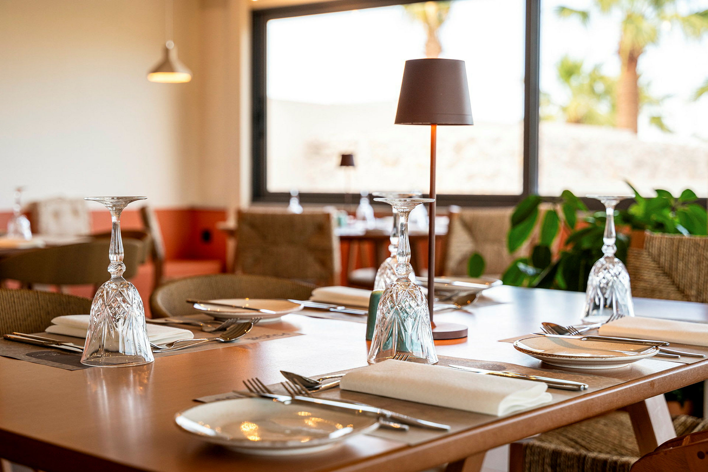 Ett dukat bord med glas, bestick och tallrikar i en restaurang. (AI-genererad text)