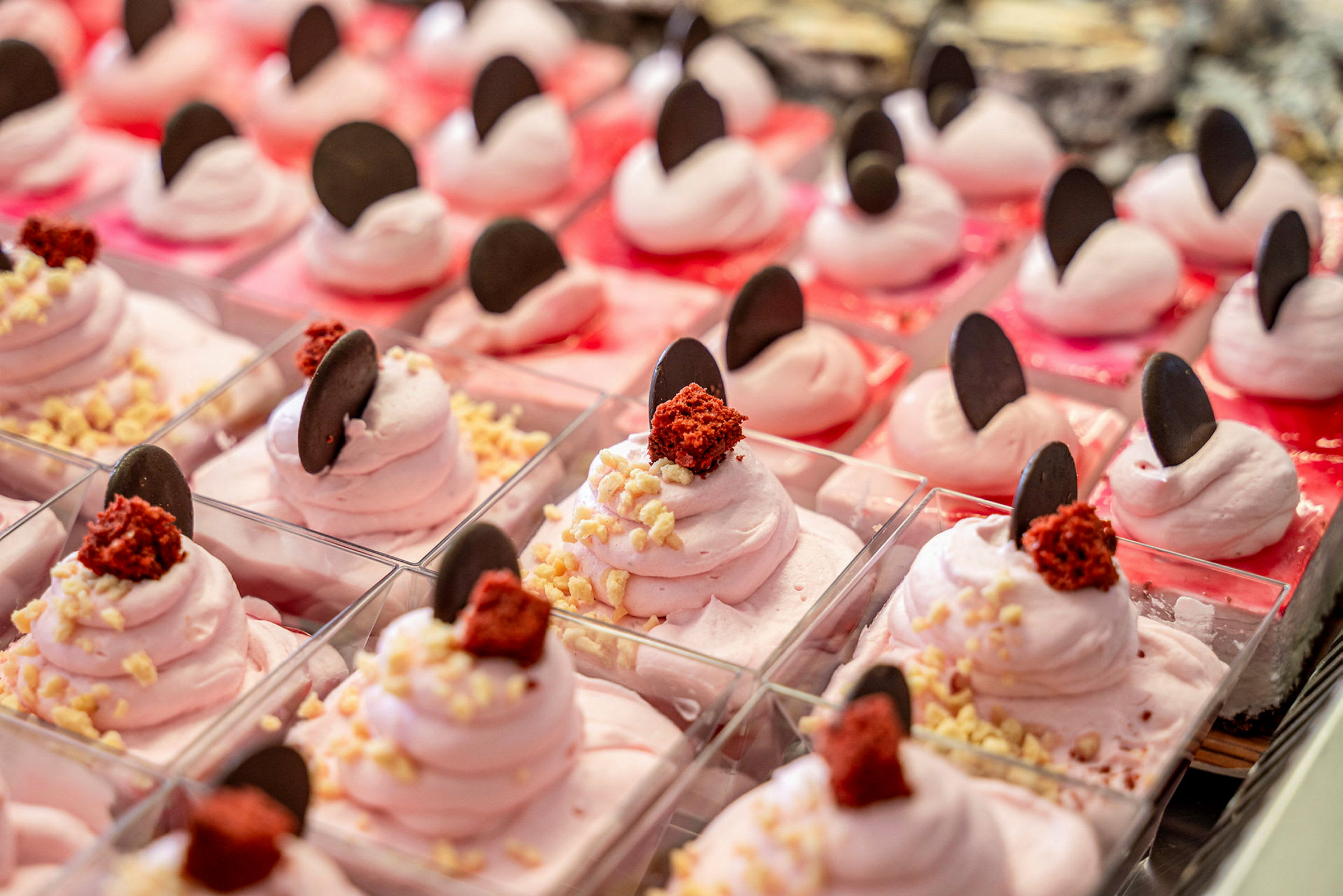 Rosa desserter dekorerade med chokladbitar och strössel. (AI-genererad text)