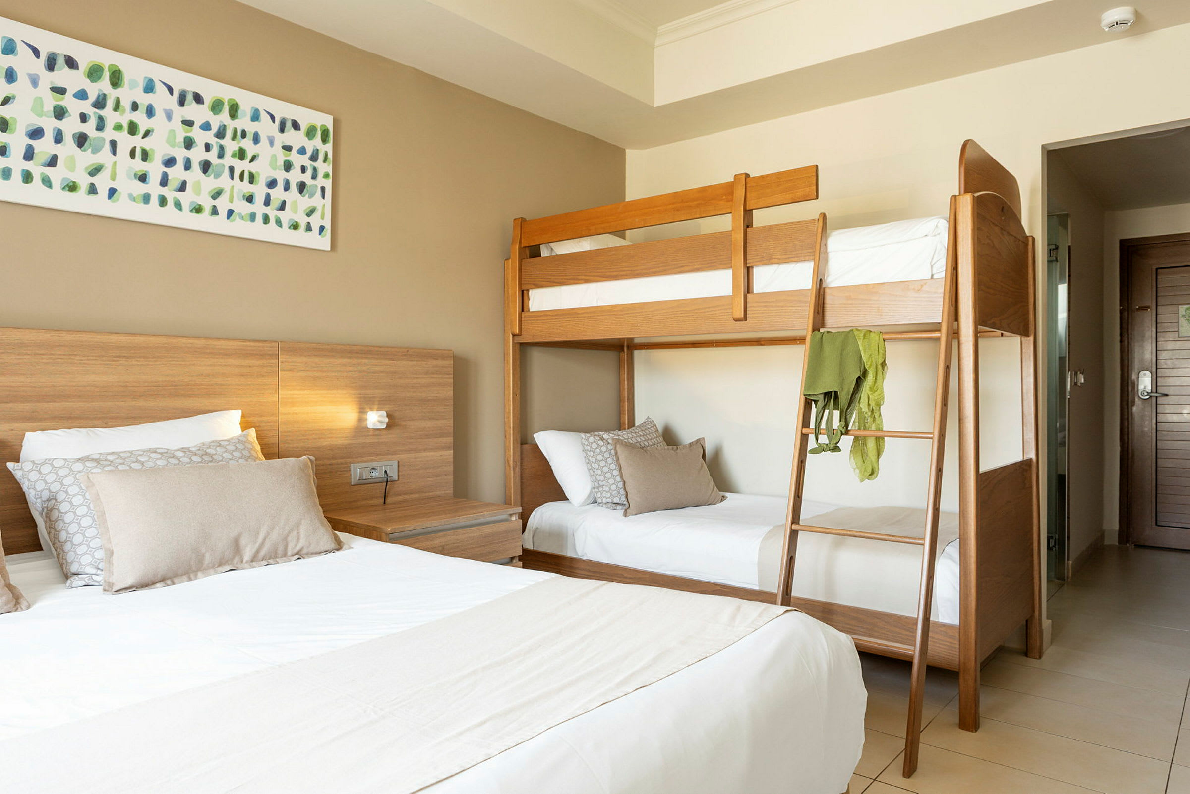Hotellrum med våningssäng och dubbelsäng. (AI-genererad text)
