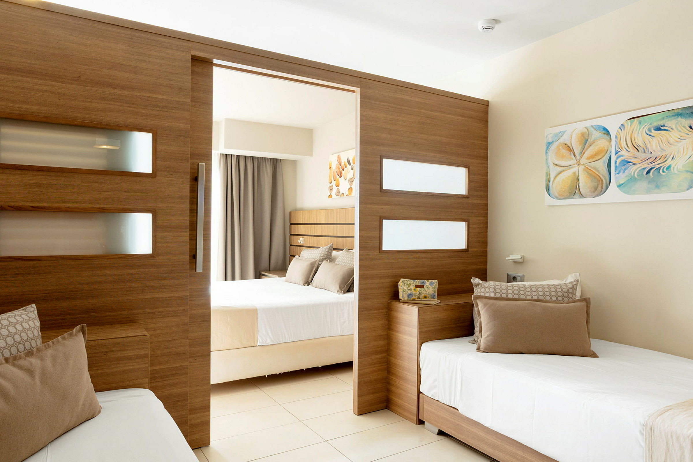 Ett hotellrum med en delad design, med två sängar och en träpanel som skiljer rummen. (AI-genererad text)