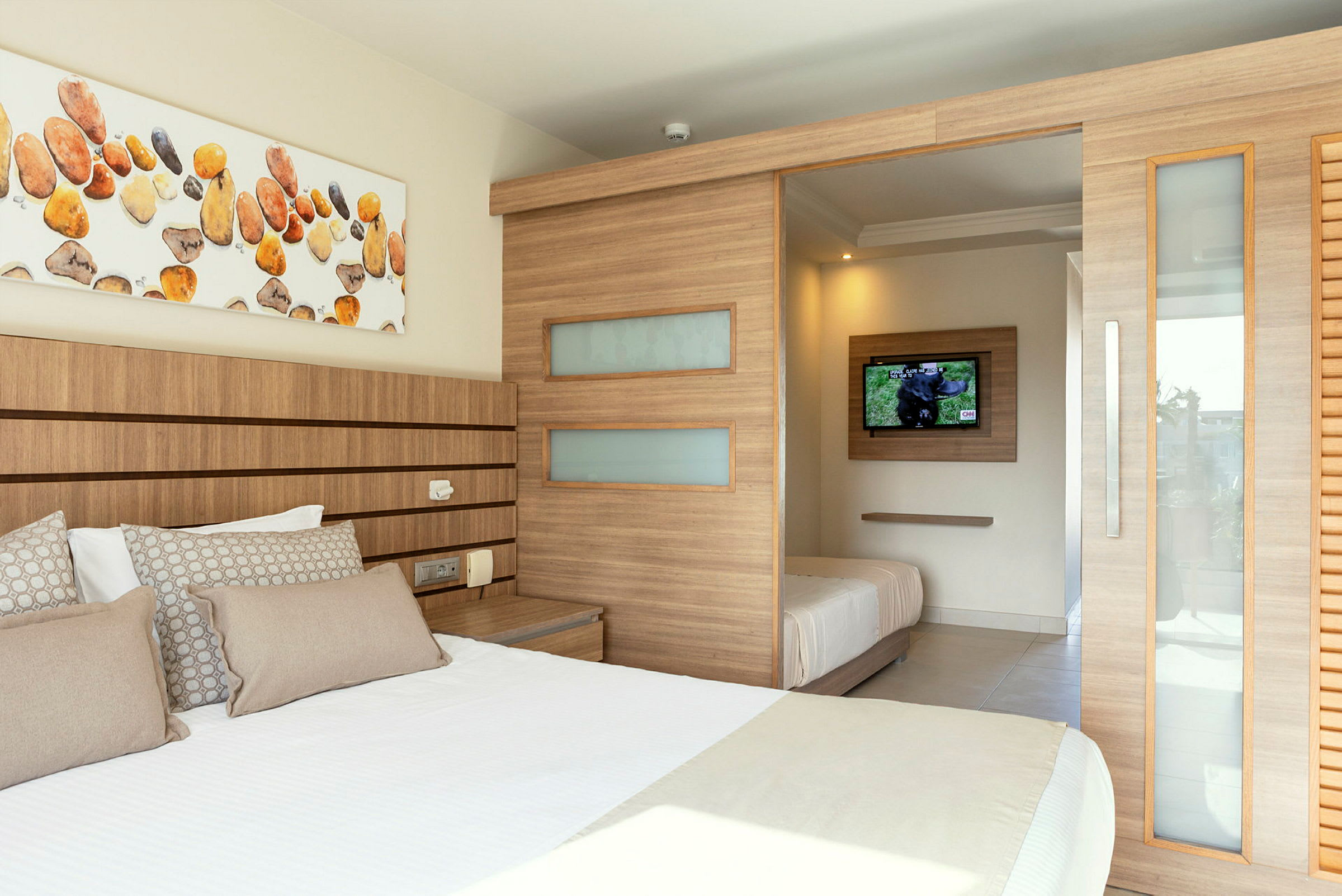 Ett hotellrum med dubbelsäng, träpanel och en TV. (AI-genererad text)