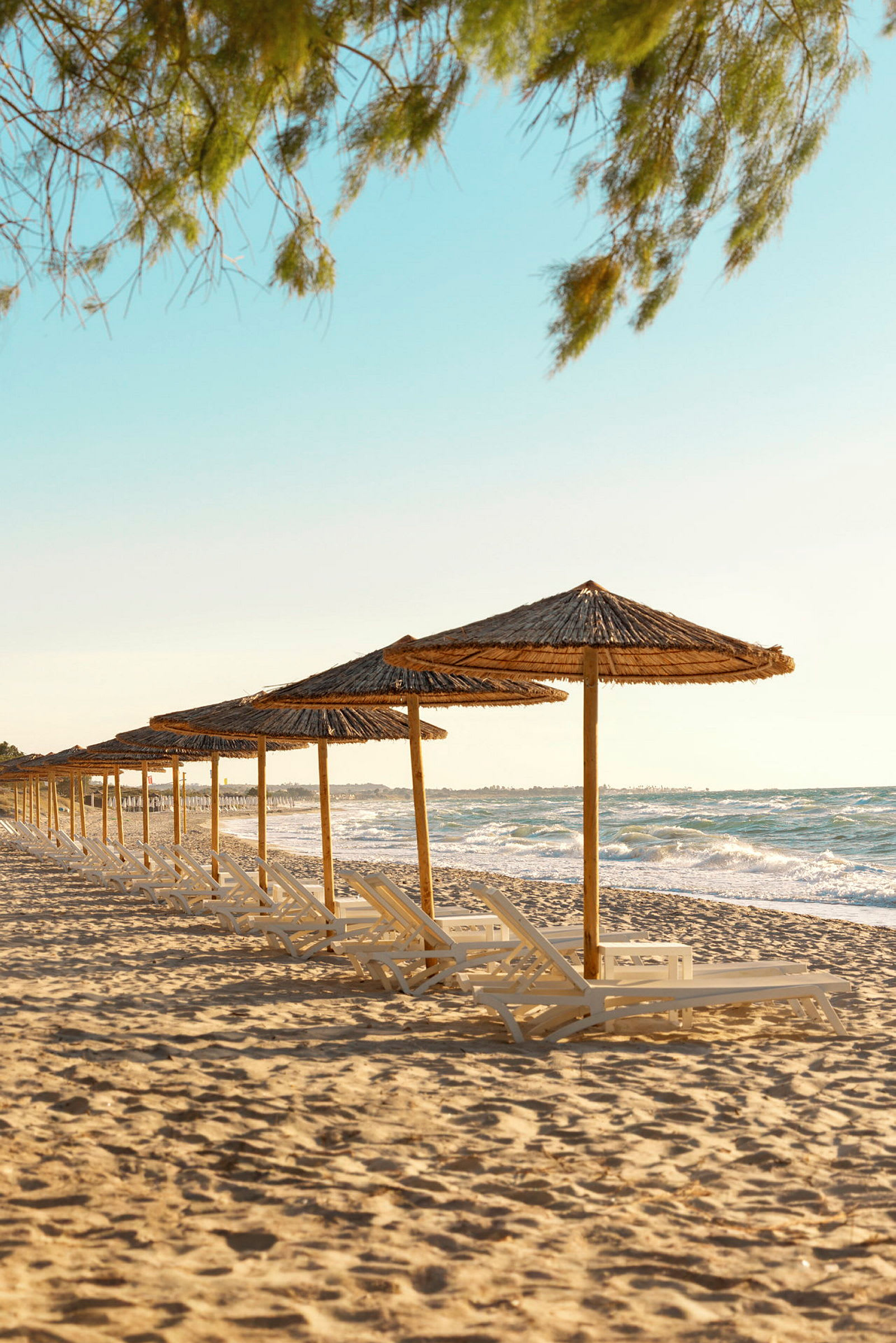 Strand med solstolar och parasoller vid havet. (AI-genererad text)