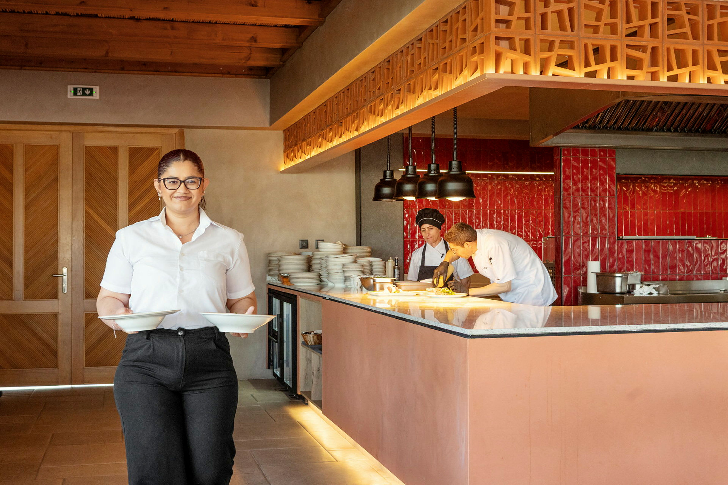 En restaurang interiör med personal och kök. (AI-genererad text)