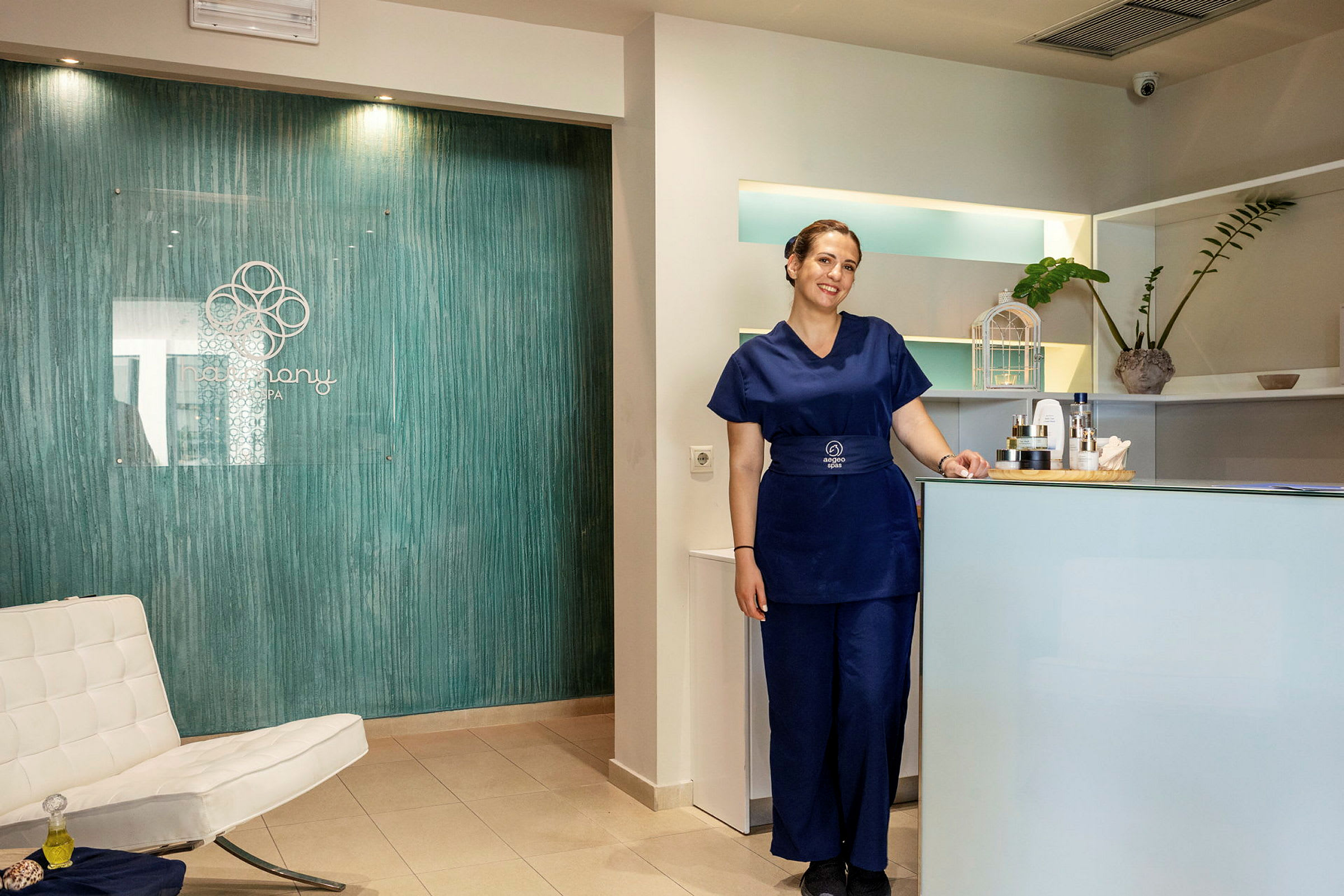 Receptionen på ett spa med en vit stol, ett blått bord, och en informationsdisk. (AI-genererad text)