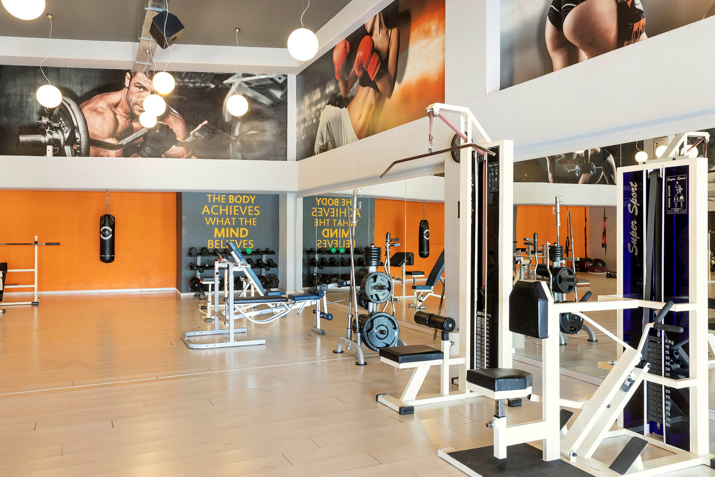 Ett gym med träningsmaskiner, gymutrustning och spegelväggar. (AI-genererad text)