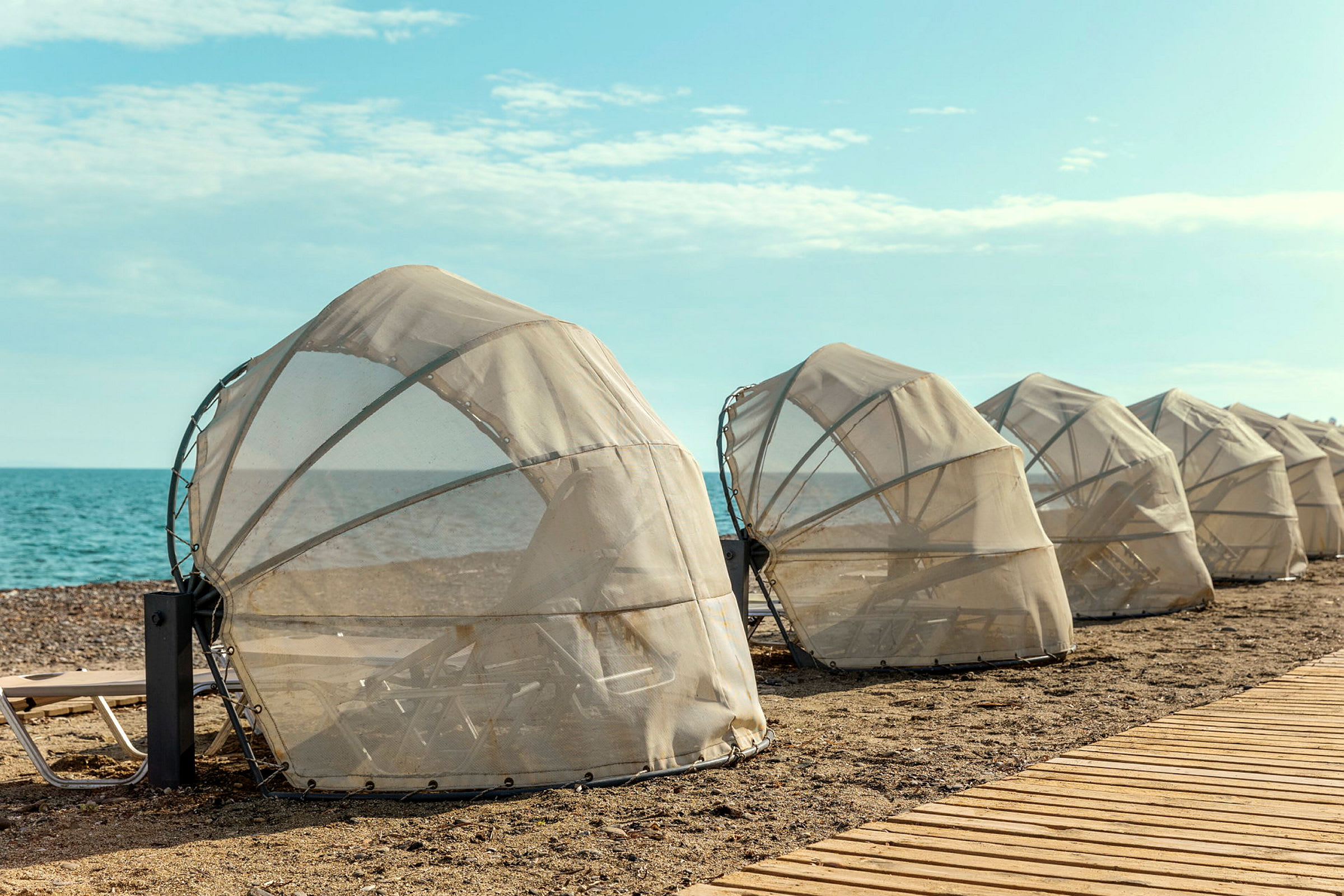 Skyddade solstolar på stranden nära havet. (AI-genererad text)