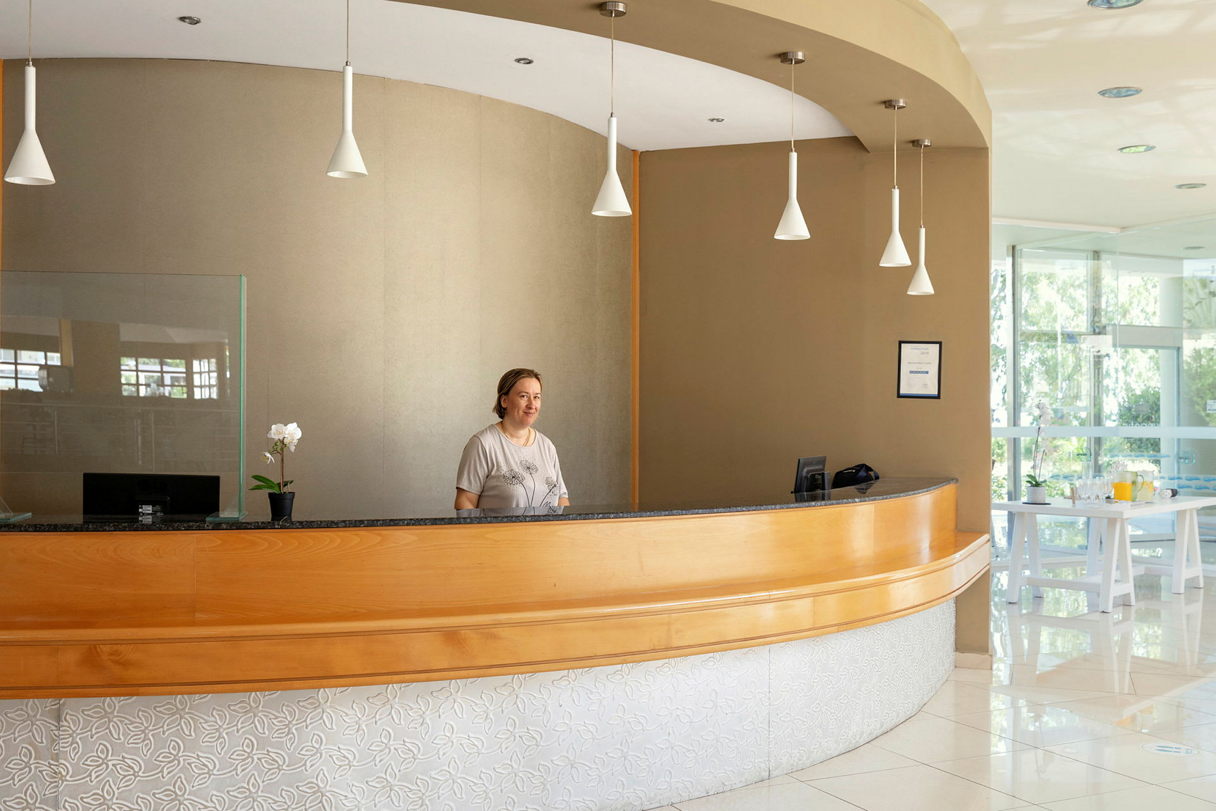 En receptionsdisk med en växt och föremål ovanpå. (AI-genererad text)
