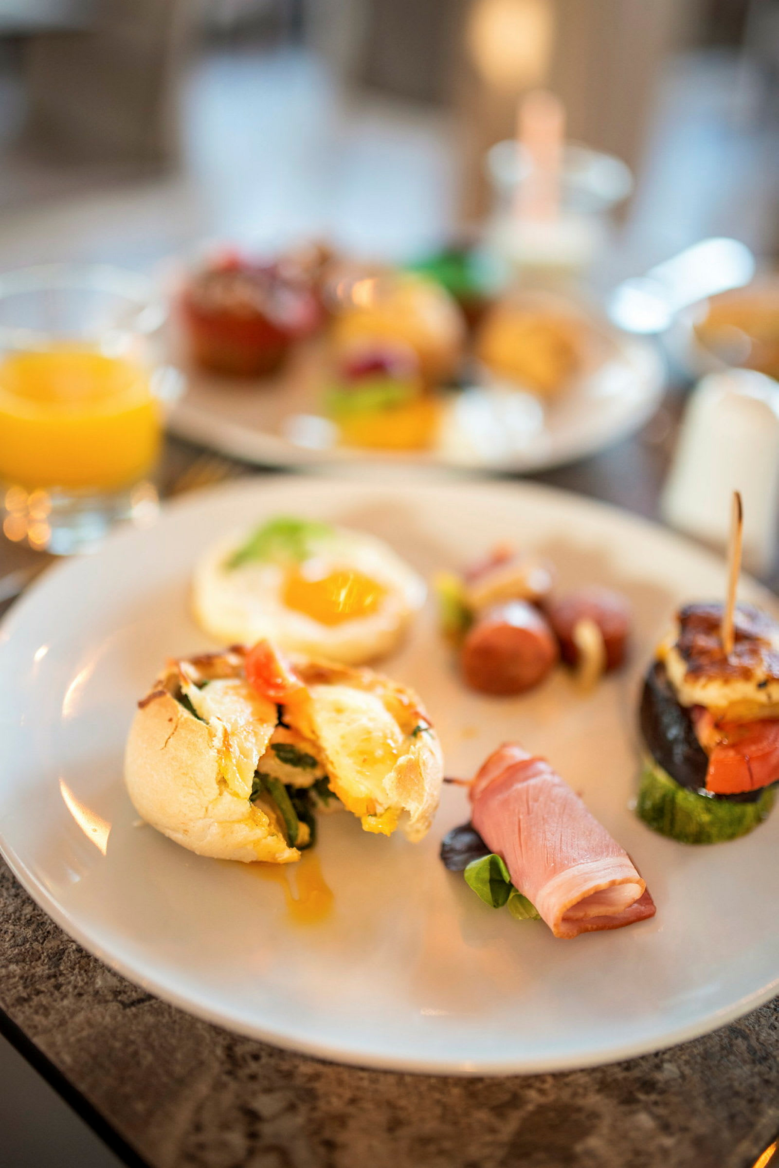 Varm frukost med olika rätter och ett glas juice serverat. (AI-genererad text)