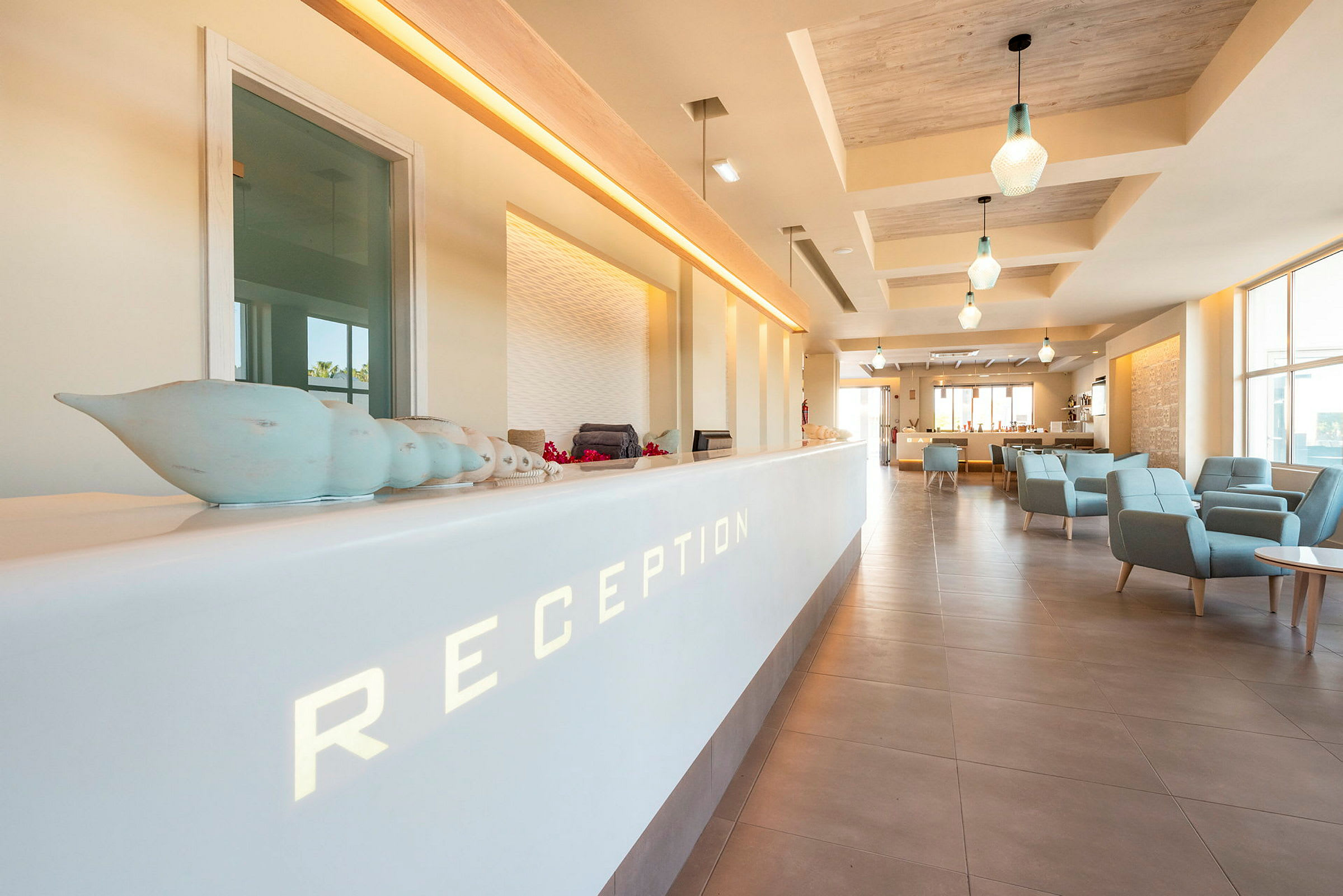 En receptionsdisk i ett ljus hotell med moderna stolar och belysning. (AI-genererad text)