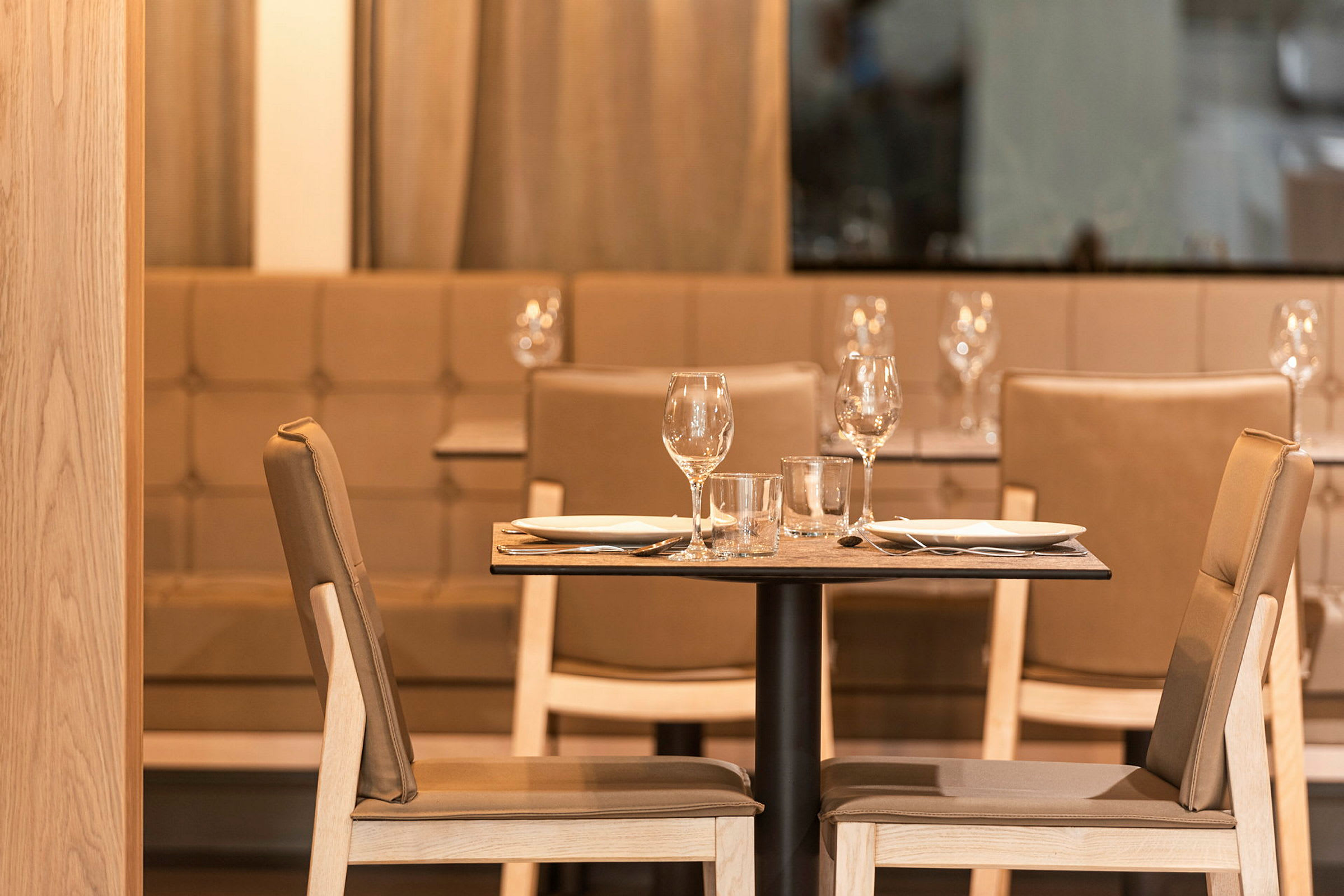 Två dukade stolar och ett bord i en restaurang. (AI-genererad text)