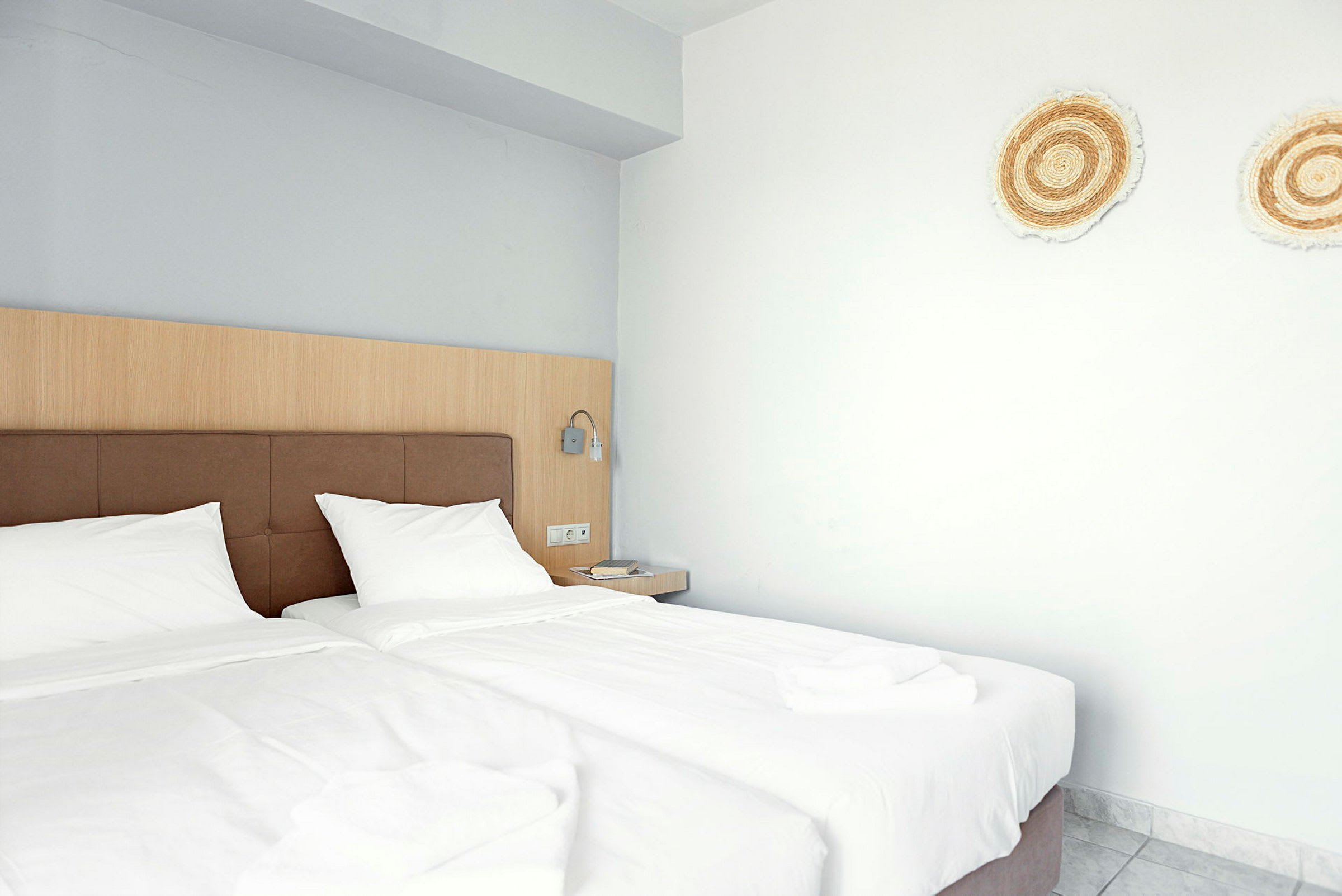 Hotellrum med två enkelsängar och dekorationer på väggen. (AI-genererad text)