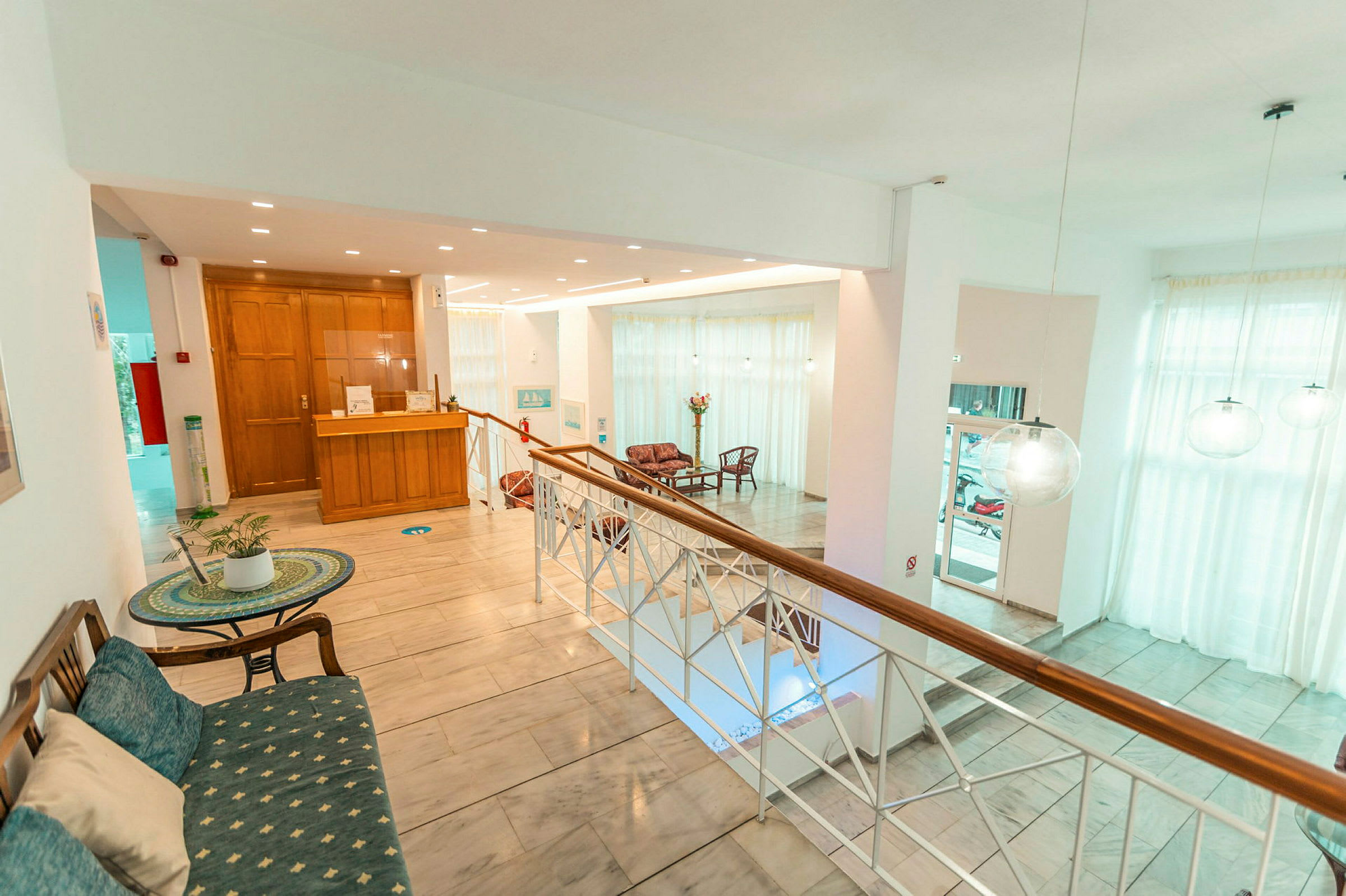 Ljus hotellobby med reception och sittgrupper. (AI-genererad text)