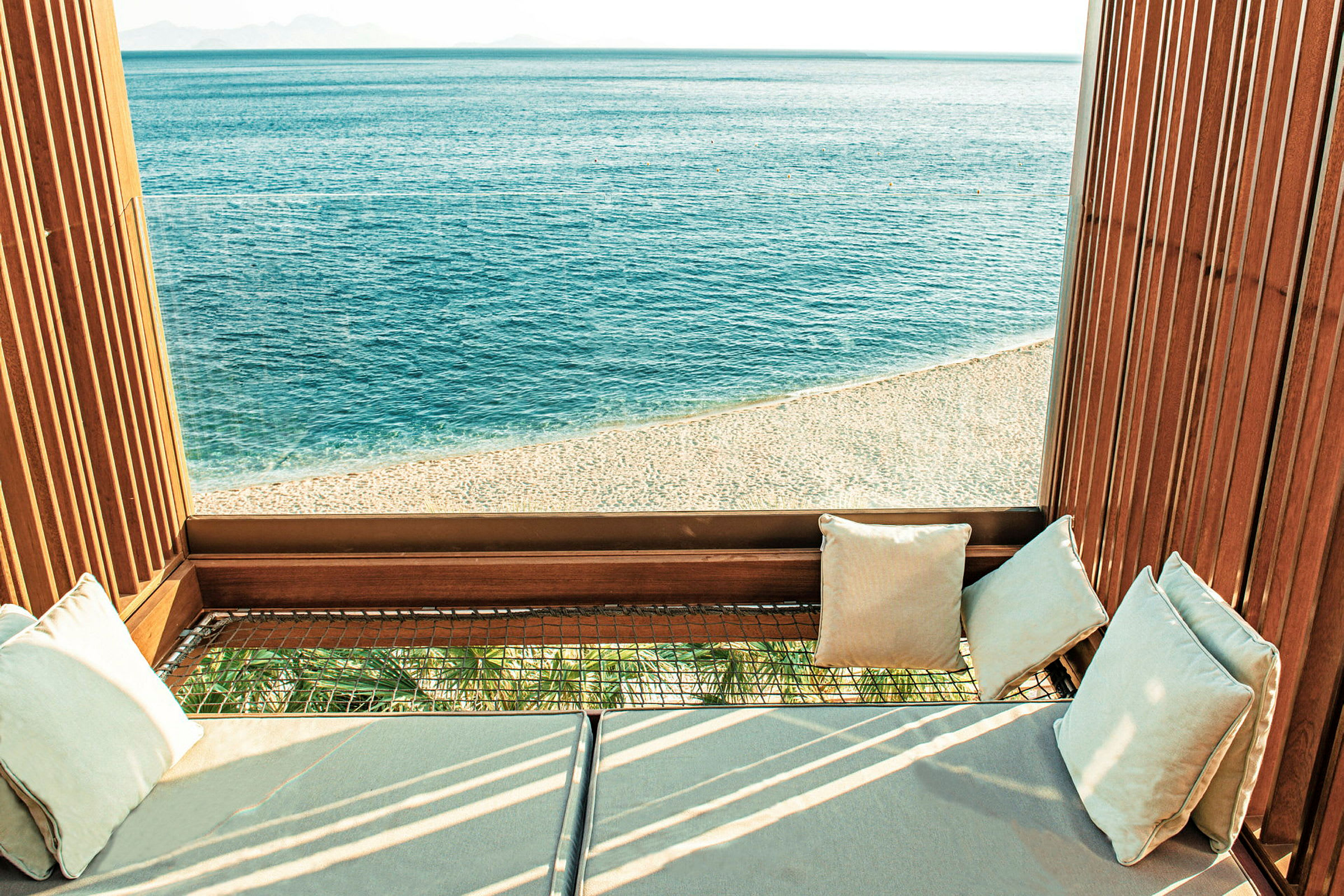 Bild av en loungeplats med utsikt över en strand och ett öppet hav. (AI-genererad text)