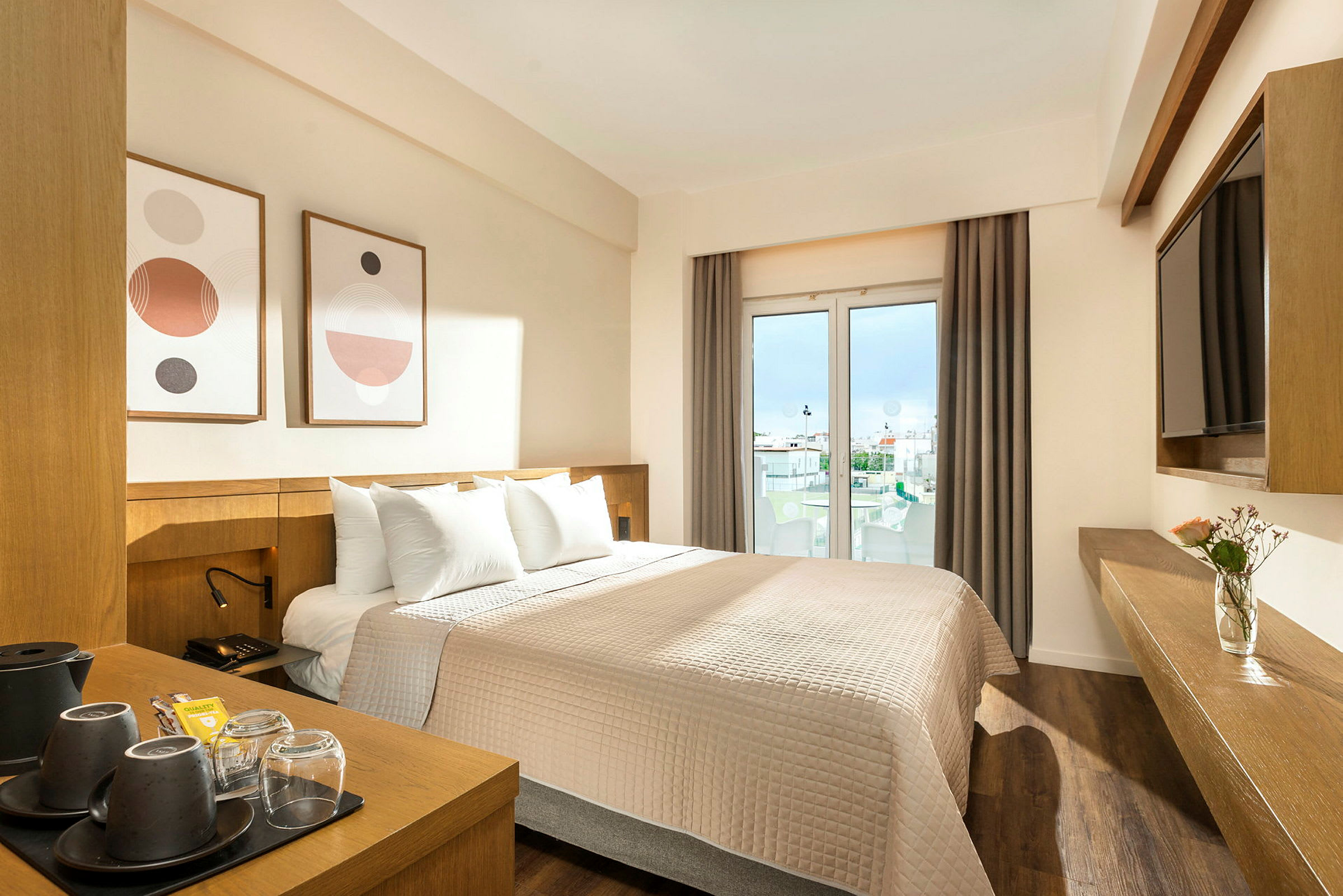 Ett hotellrum med en dubbelsäng, modern inredning och fönster som visar utsikt mot staden. (AI-genererad text)