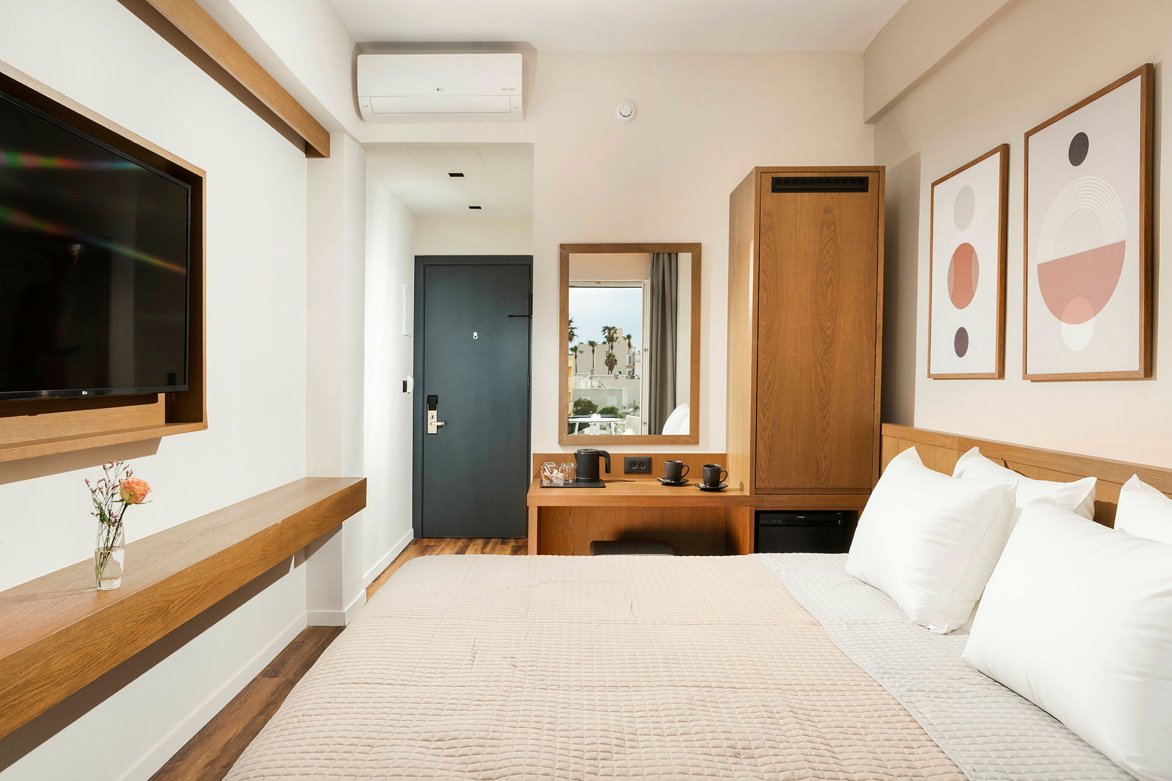 En modern hotellrumsinredning med säng, väggmonterad TV och dekoration. (AI-genererad text)