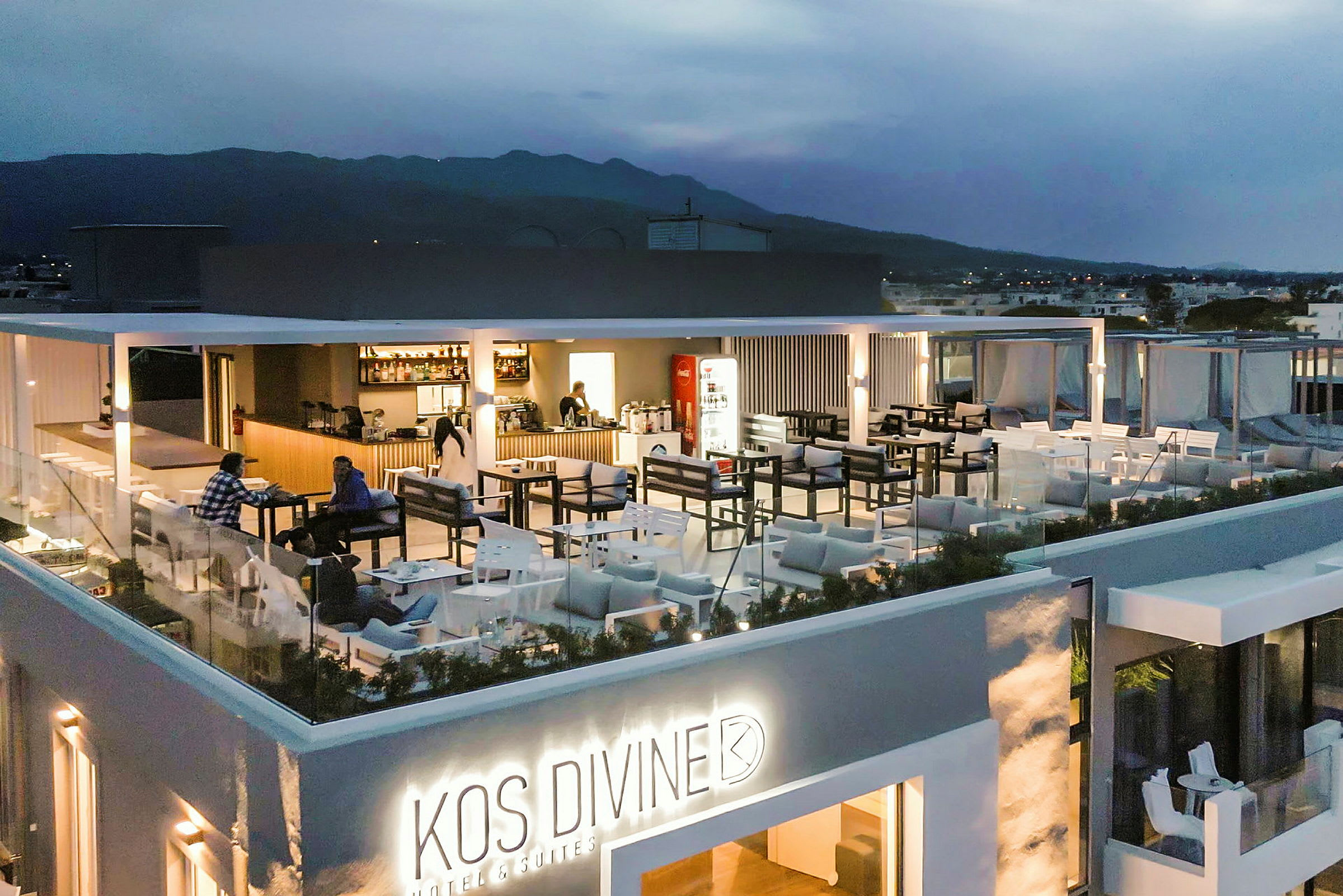 Bild av en upplyst takrestaurang på ett hotell med utemöbler och utsikt över omkringliggande landskap. (AI-genererad text)