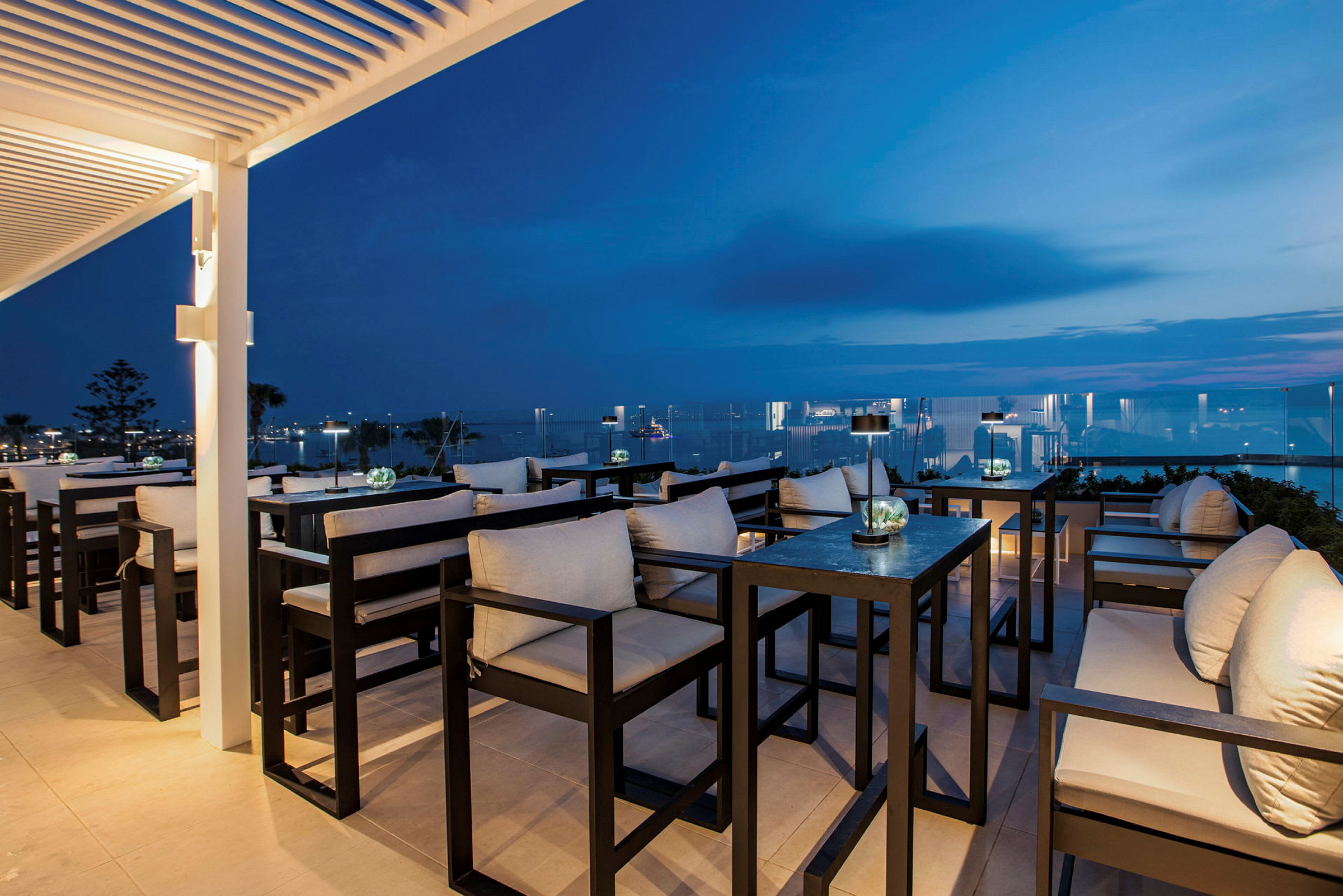 Elegant terrasslounge med sittplatser och utsikt över natthimlen och havet. (AI-genererad text)