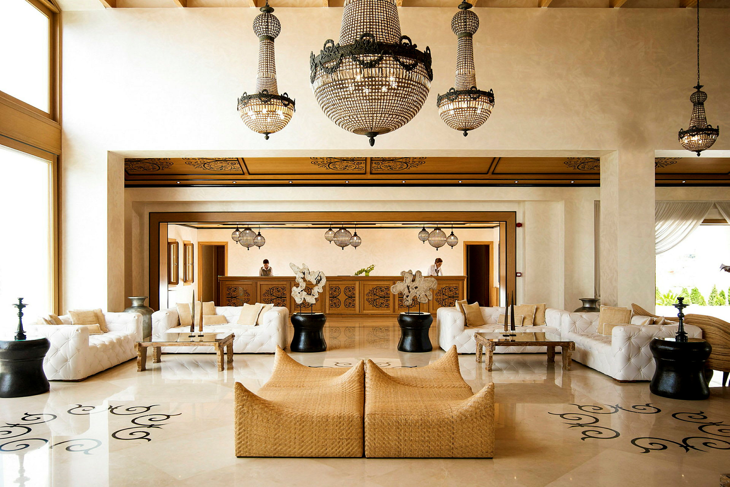 Hotellobby med soffgrupper och kristallkronor i taket. (AI-genererad text)