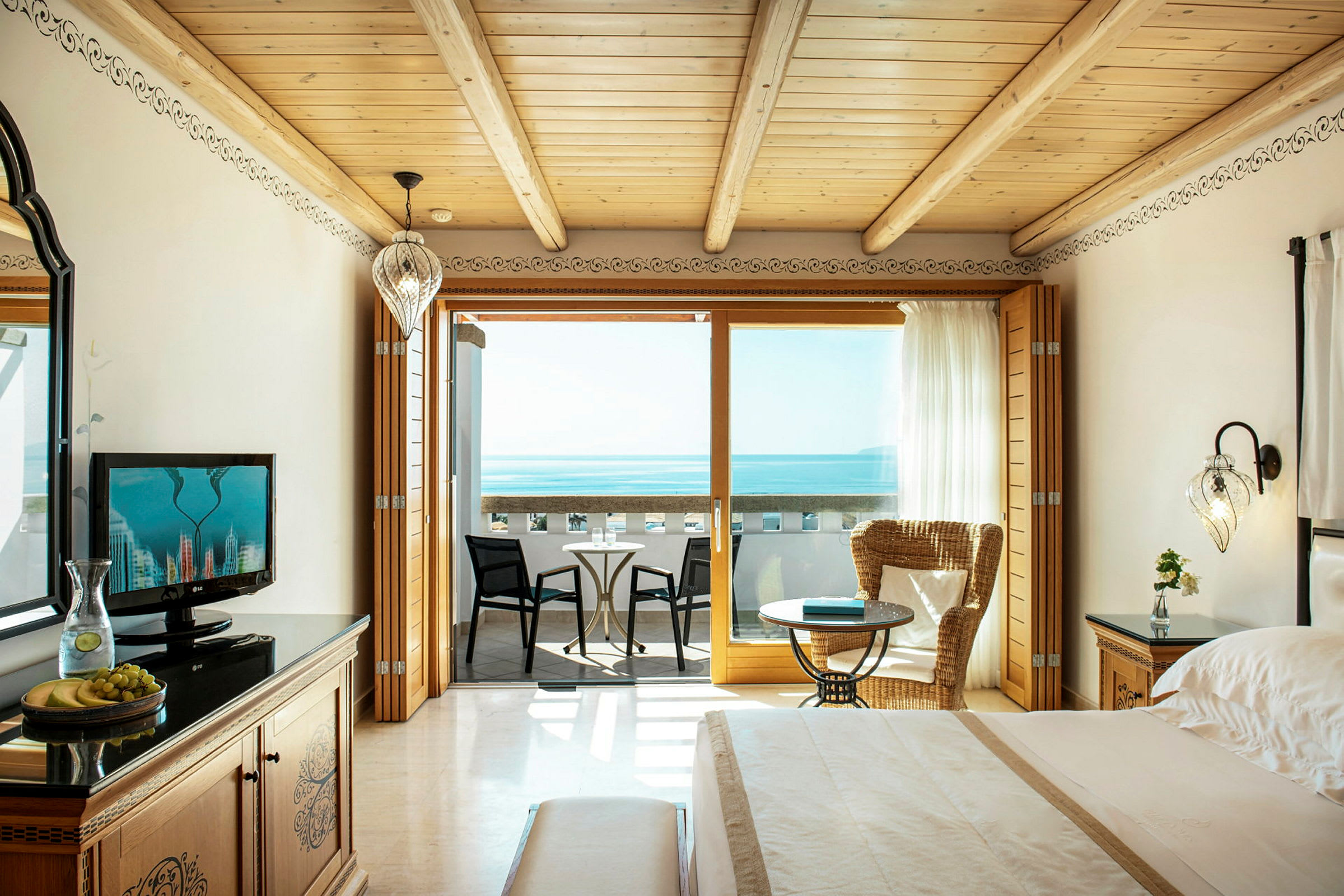 En hotellrum med utsikt över havet, inklusive en balkong med sittplatser. (AI-genererad text)