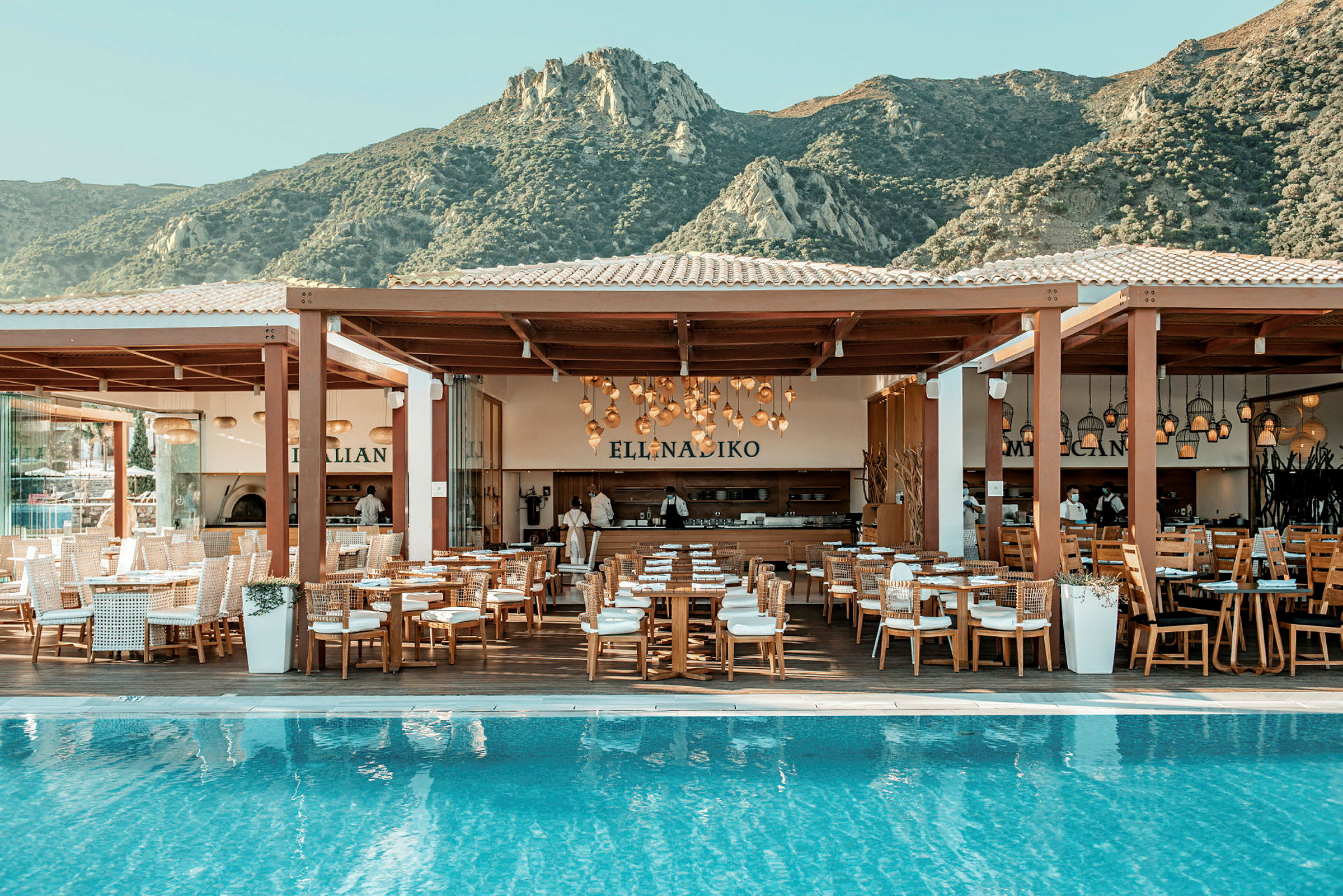 En restaurang vid en pool med utsikt över berg. (AI-genererad text)