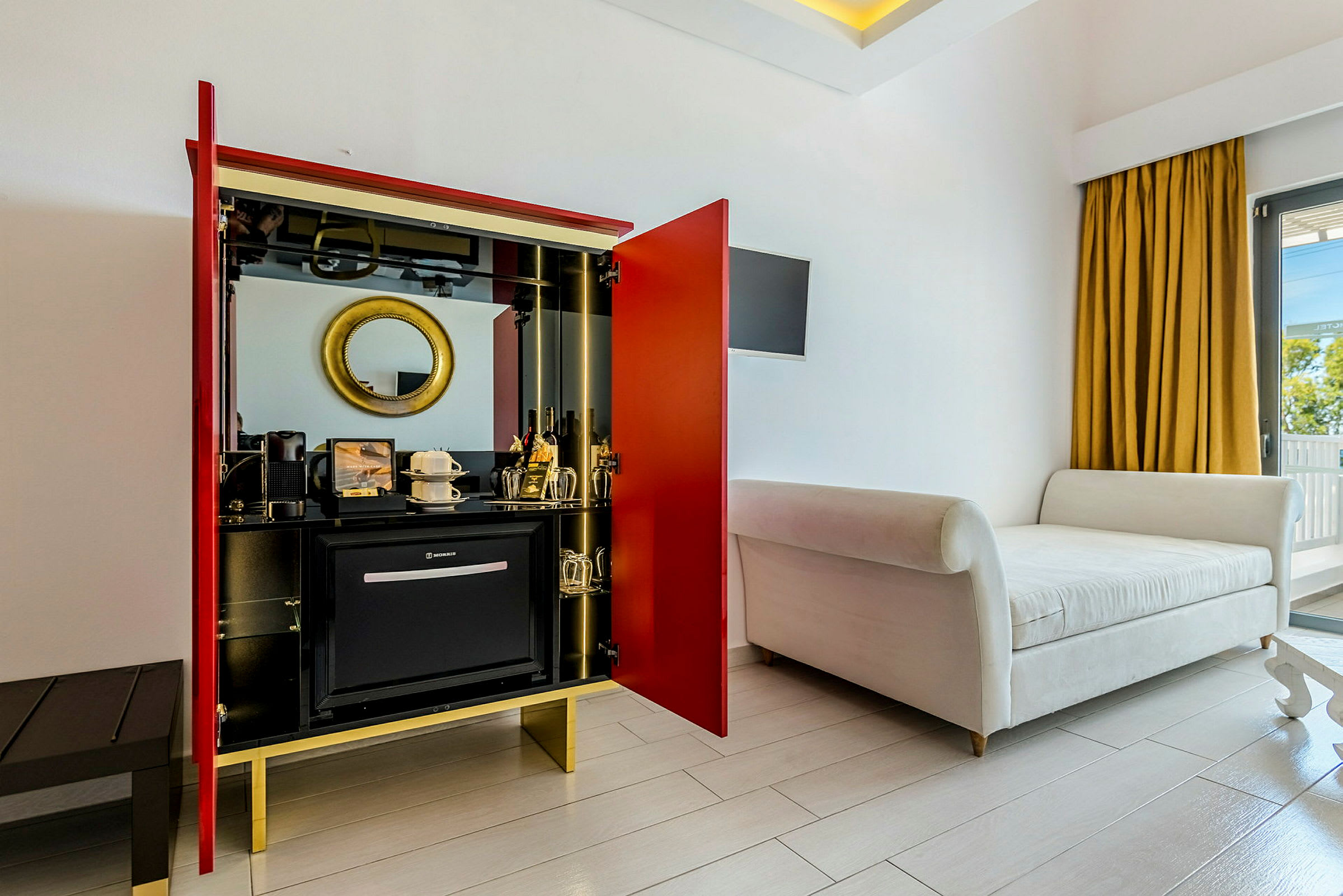 Hotellrum med en sittmöbel, garderob och minibar. (AI-genererad text)