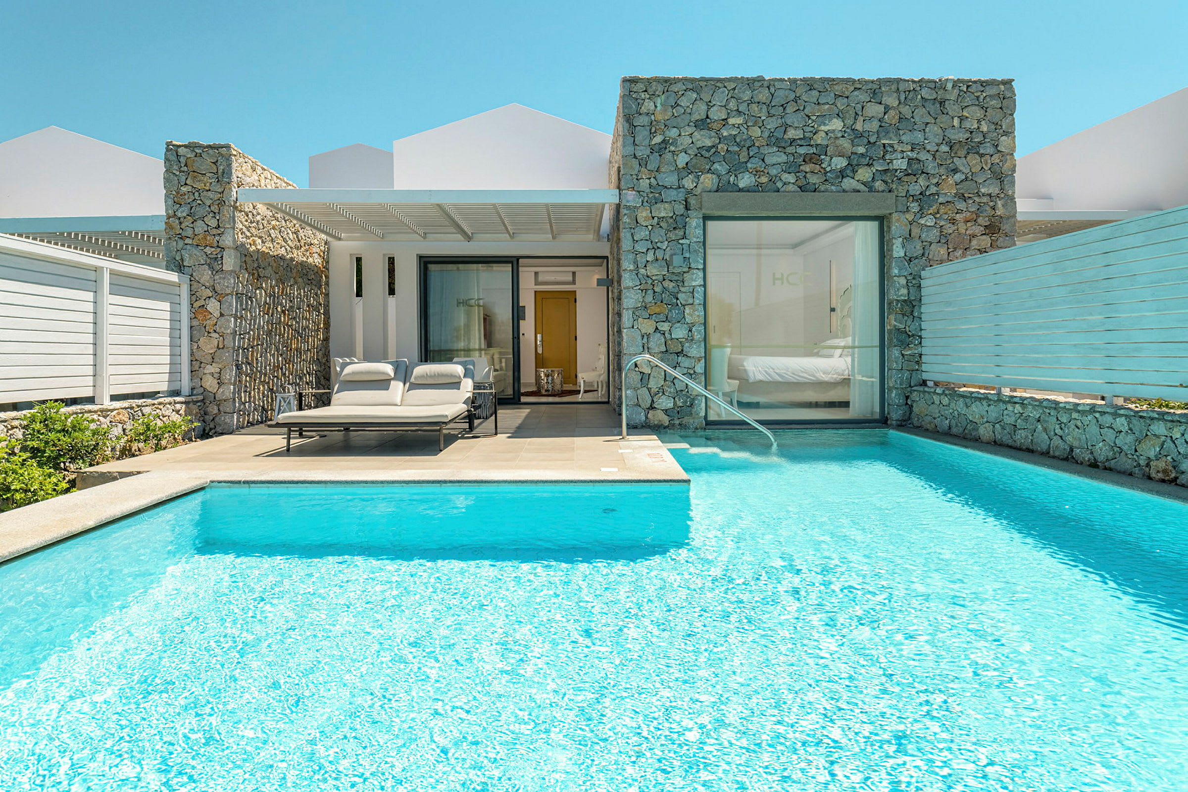En villa med pool och solstolar vid ingången. (AI-genererad text)
