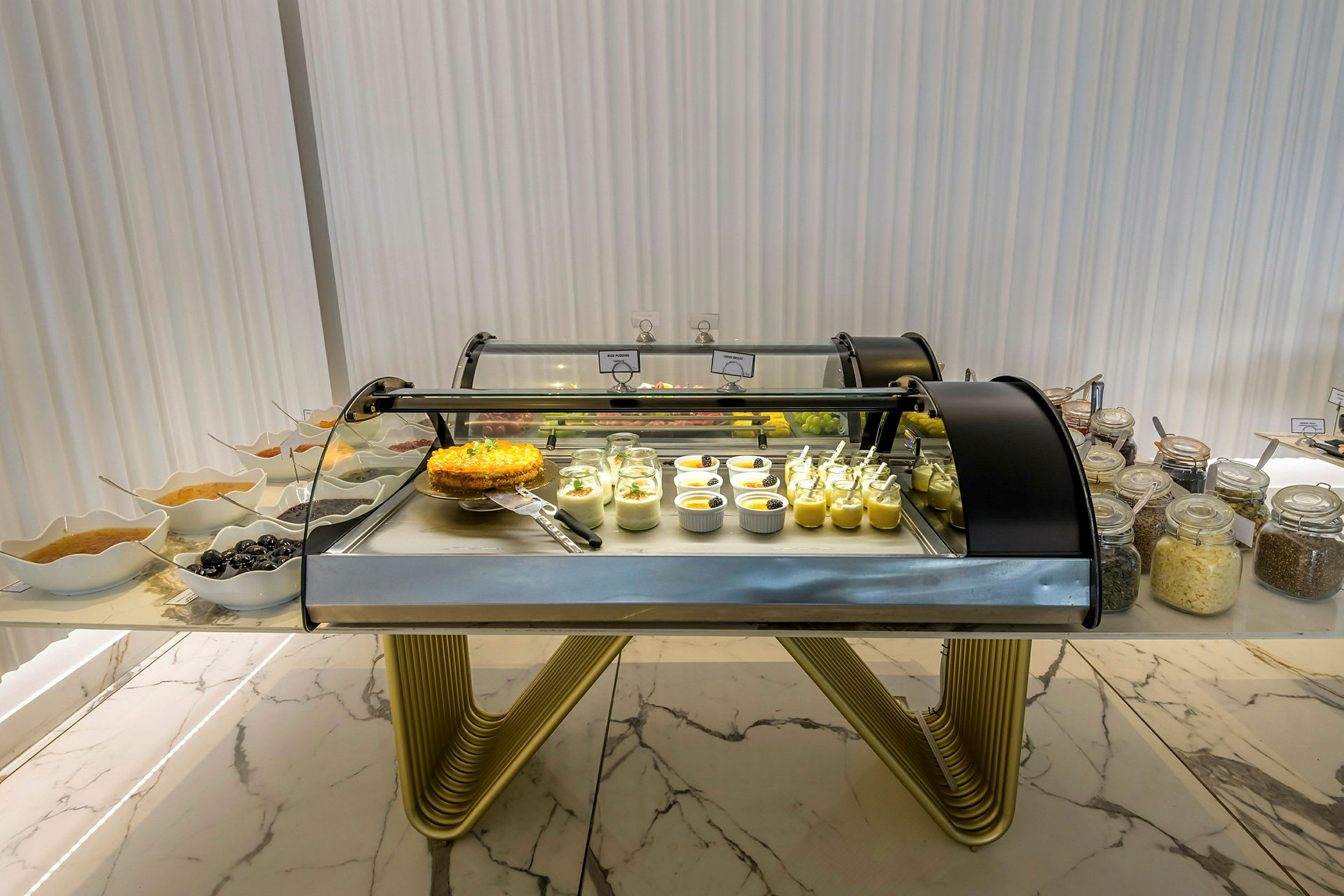 En buffédisk med desserter, inklusive glas och skålar med olika efterrätter. (AI-genererad text)