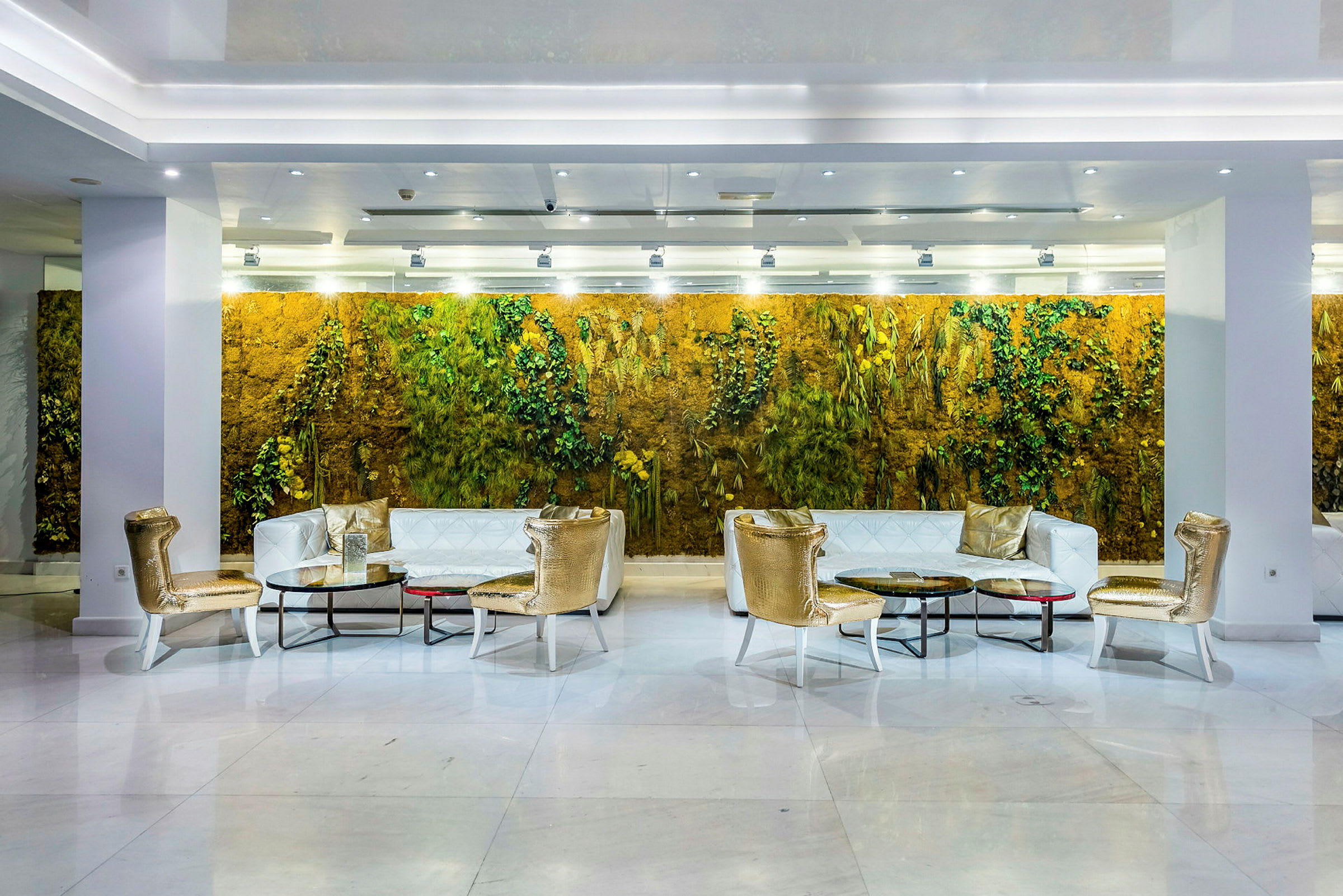 En hotellobby med sittgrupper och en grön vägg i bakgrunden. (AI-genererad text)