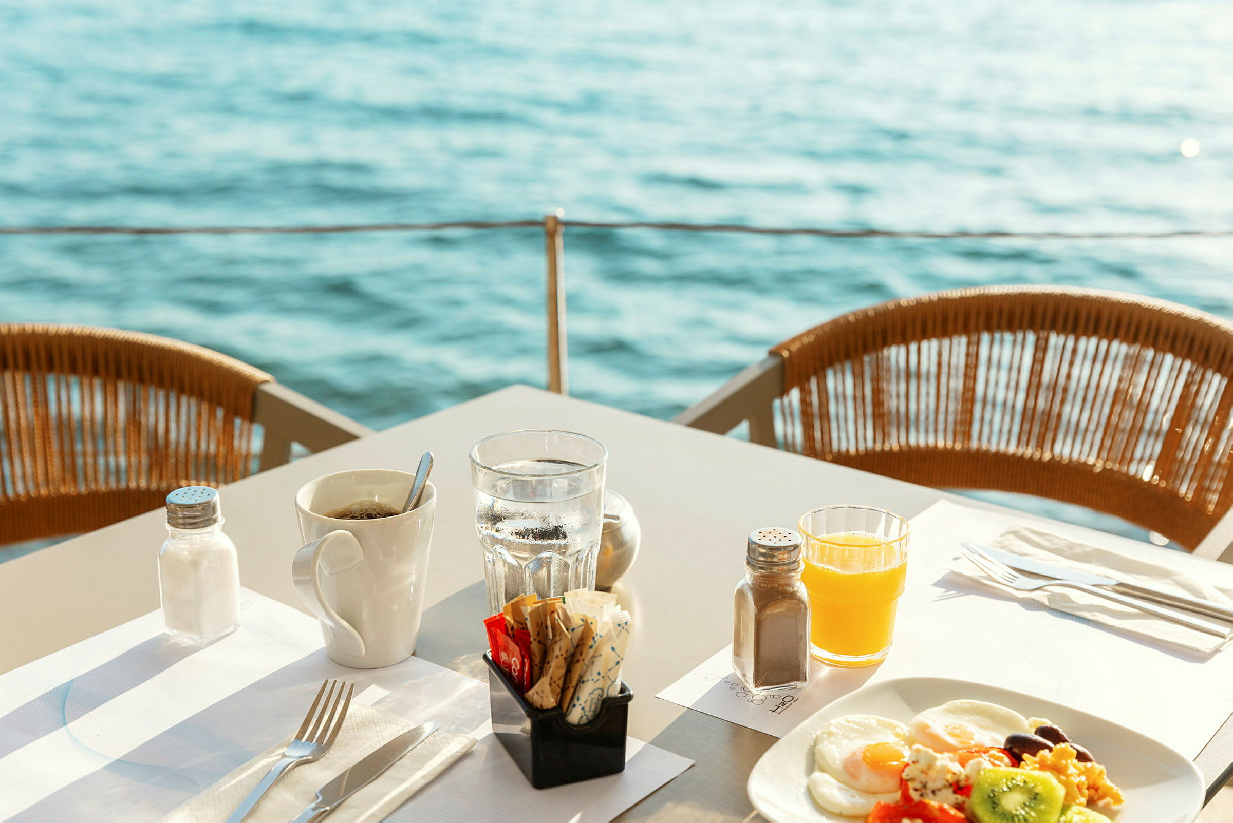 Frukost serverad vid bord med utsikt över vattnet. (AI-genererad text)