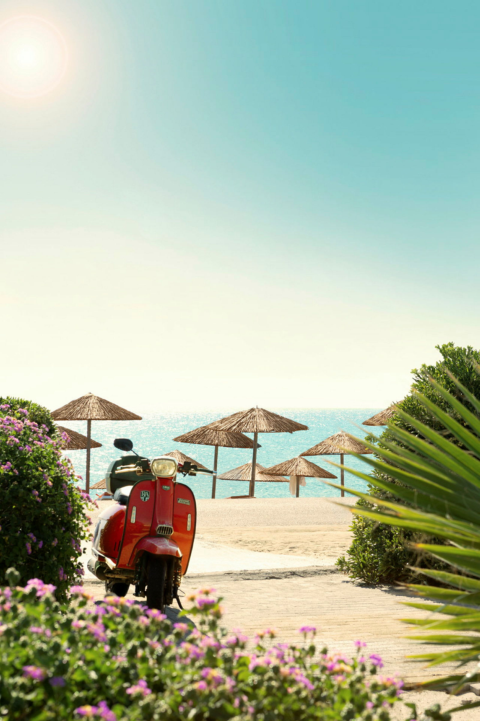 En röd vespa står vid en strand med flera parasoller av strå under en solig himmel. (AI-genererad text)
