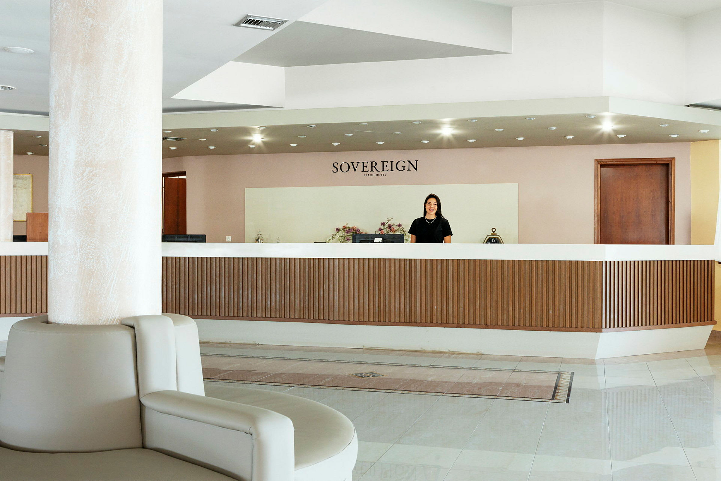 Hotellreception med namnet "Sovereign Beach Hotel" ovanför. (AI-genererad text)