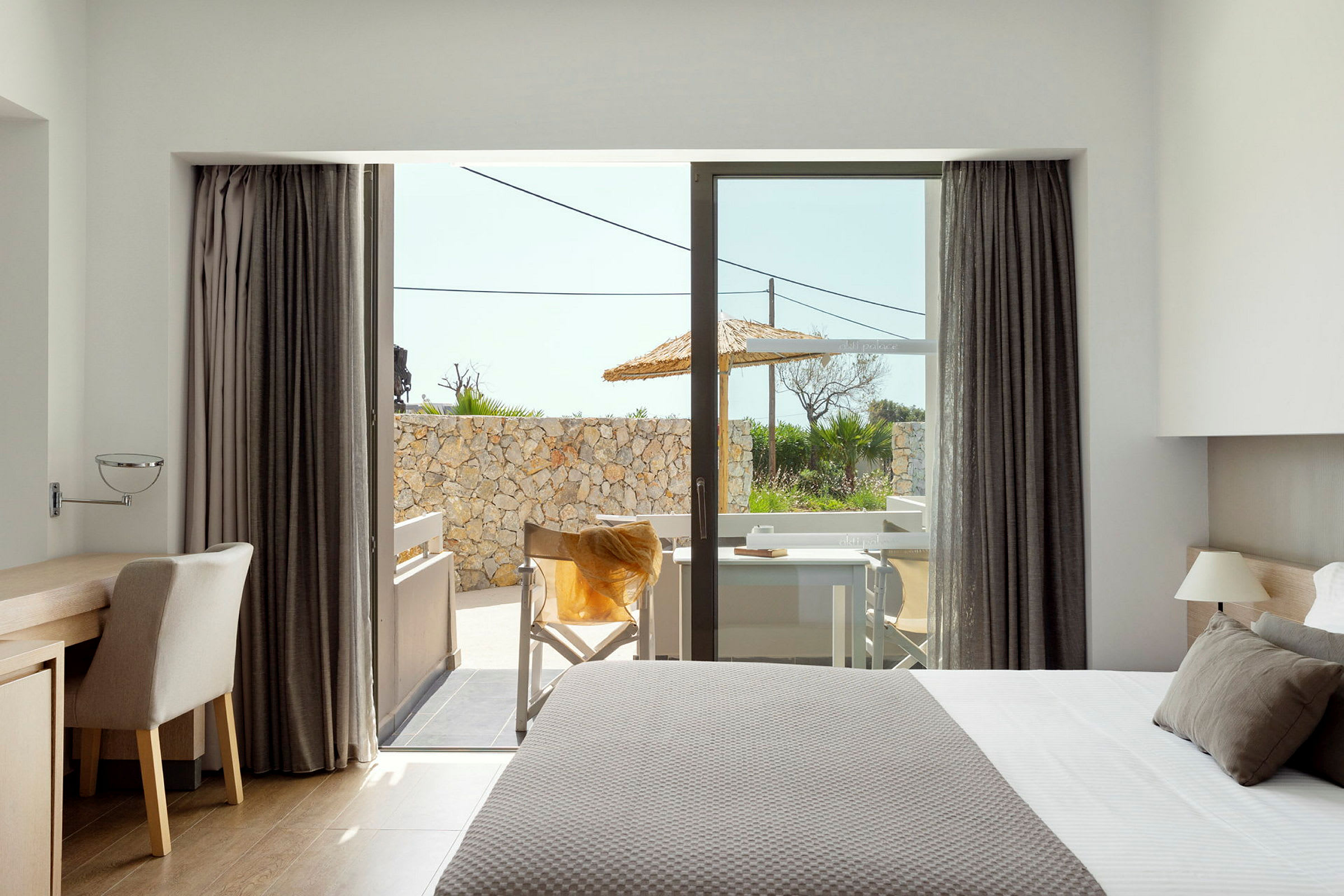Modernt hotellrum med utsikt över en terrass. (AI-genererad text)