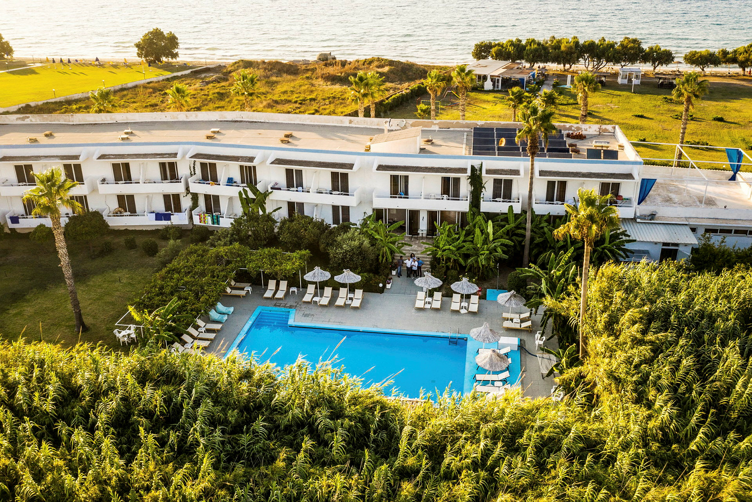 Hotell med pool och omgivande grönska nära stranden. (AI-genererad text)