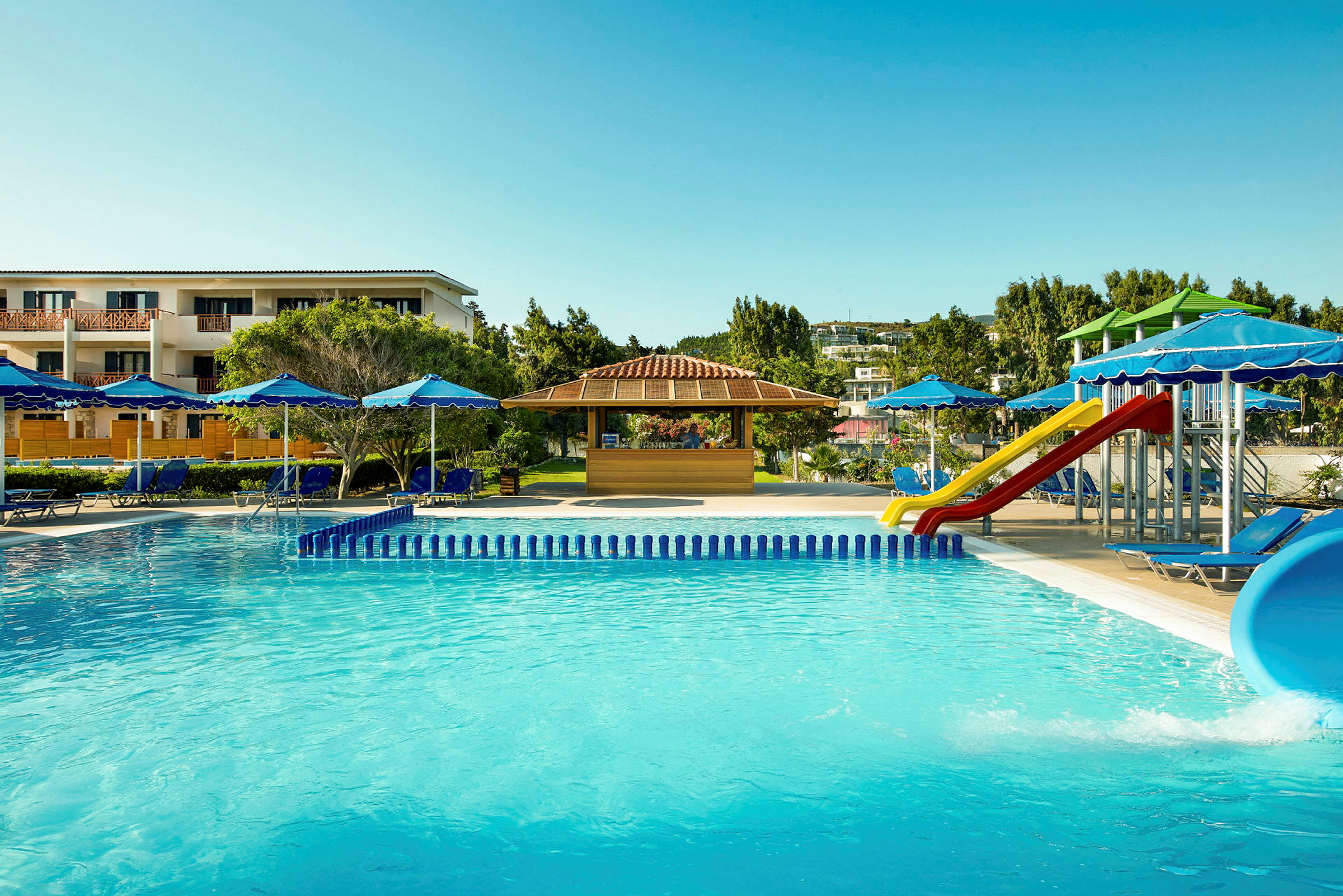 Bild av en hotellpool, solstolar med parasoll och en lekplats med rutschkanor. (AI-genererad text)