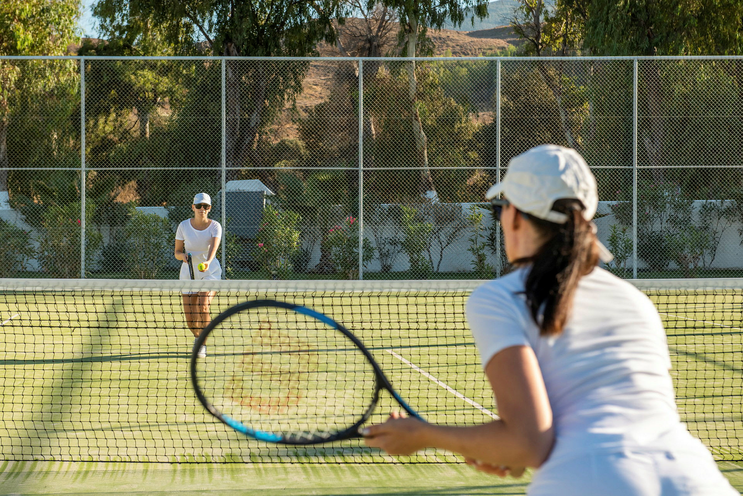 Två personer spelar tennis på en gräsbana. (AI-genererad text)