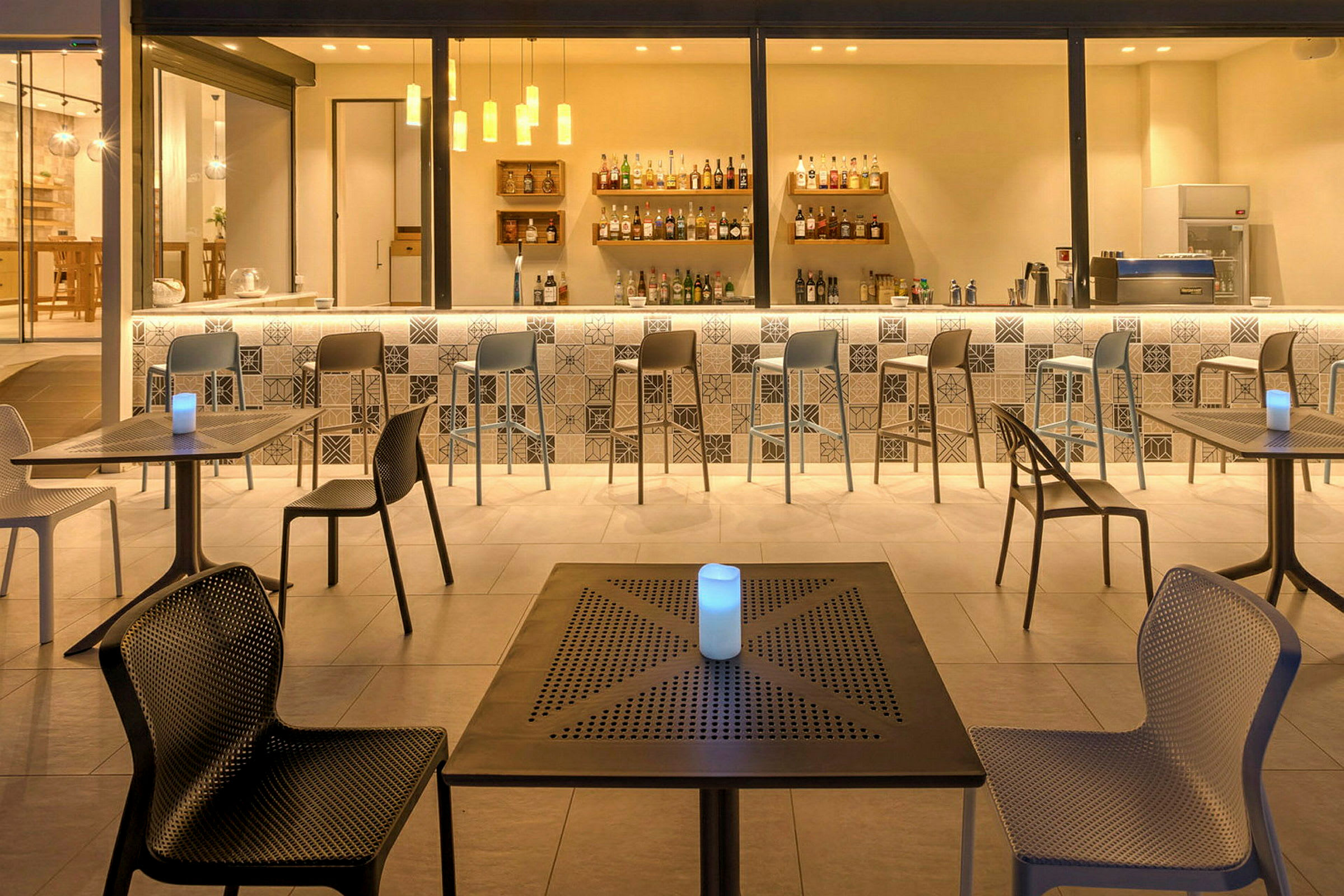 En modern bar med sittplatser vid borden och barstolar vid bardisken. (AI-genererad text)