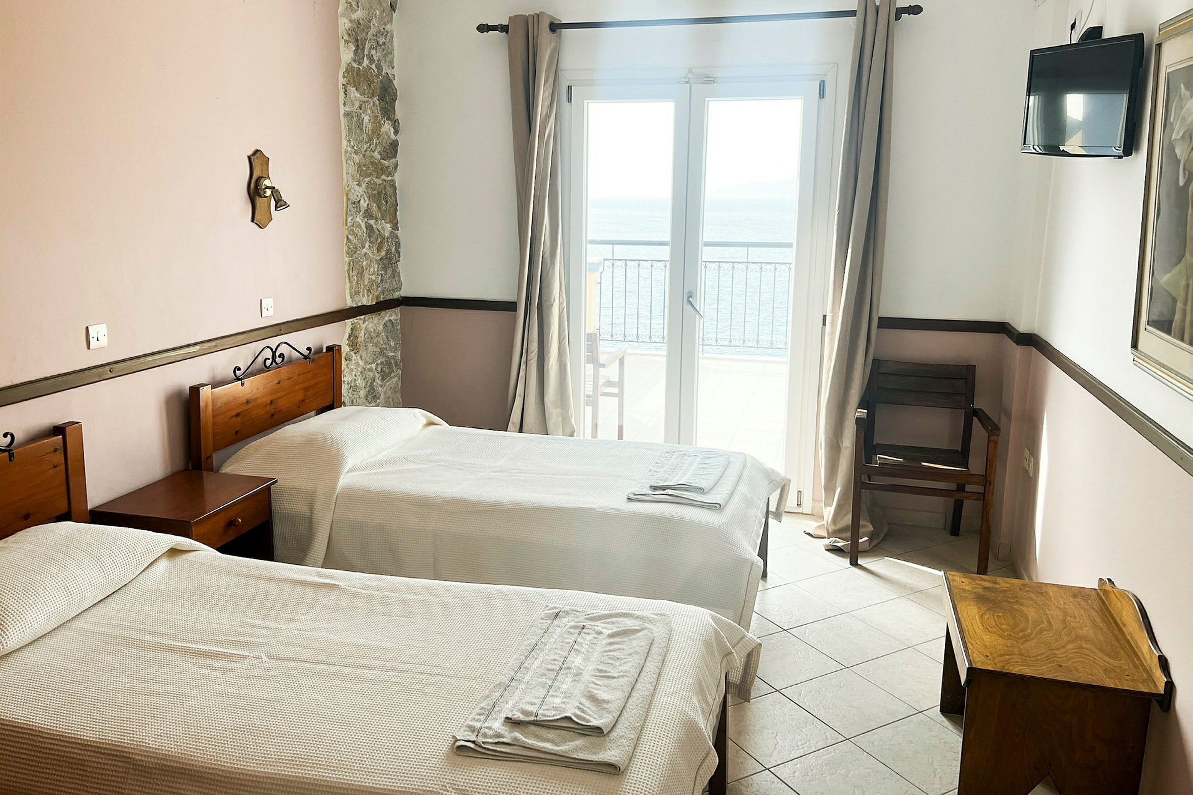 Hotellrum med två enkelsängar, ett fönster med havsutsikt. (AI-genererad text)
