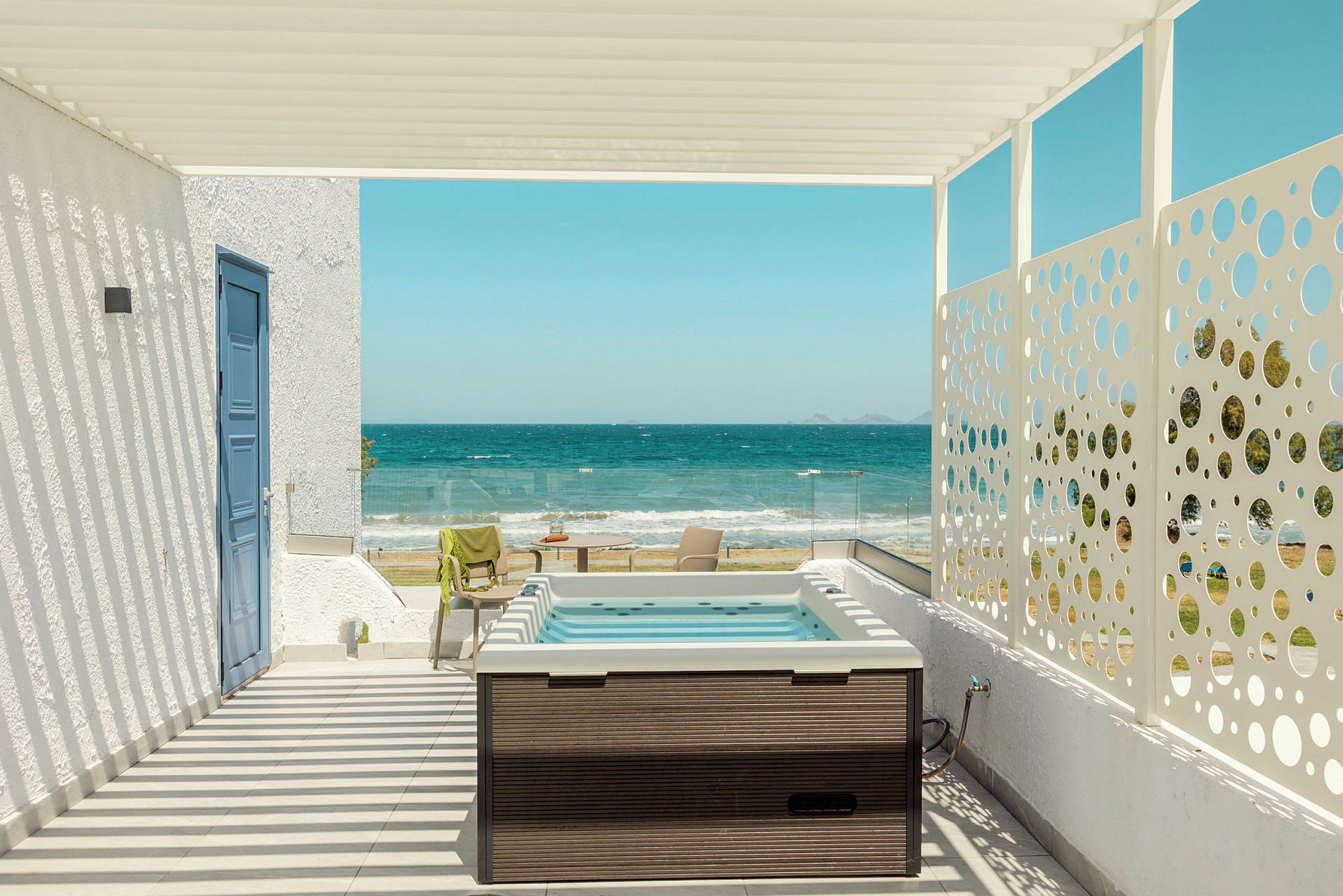 Terrass med jacuzzi, havsutsikt och solstolar. (AI-genererad text)