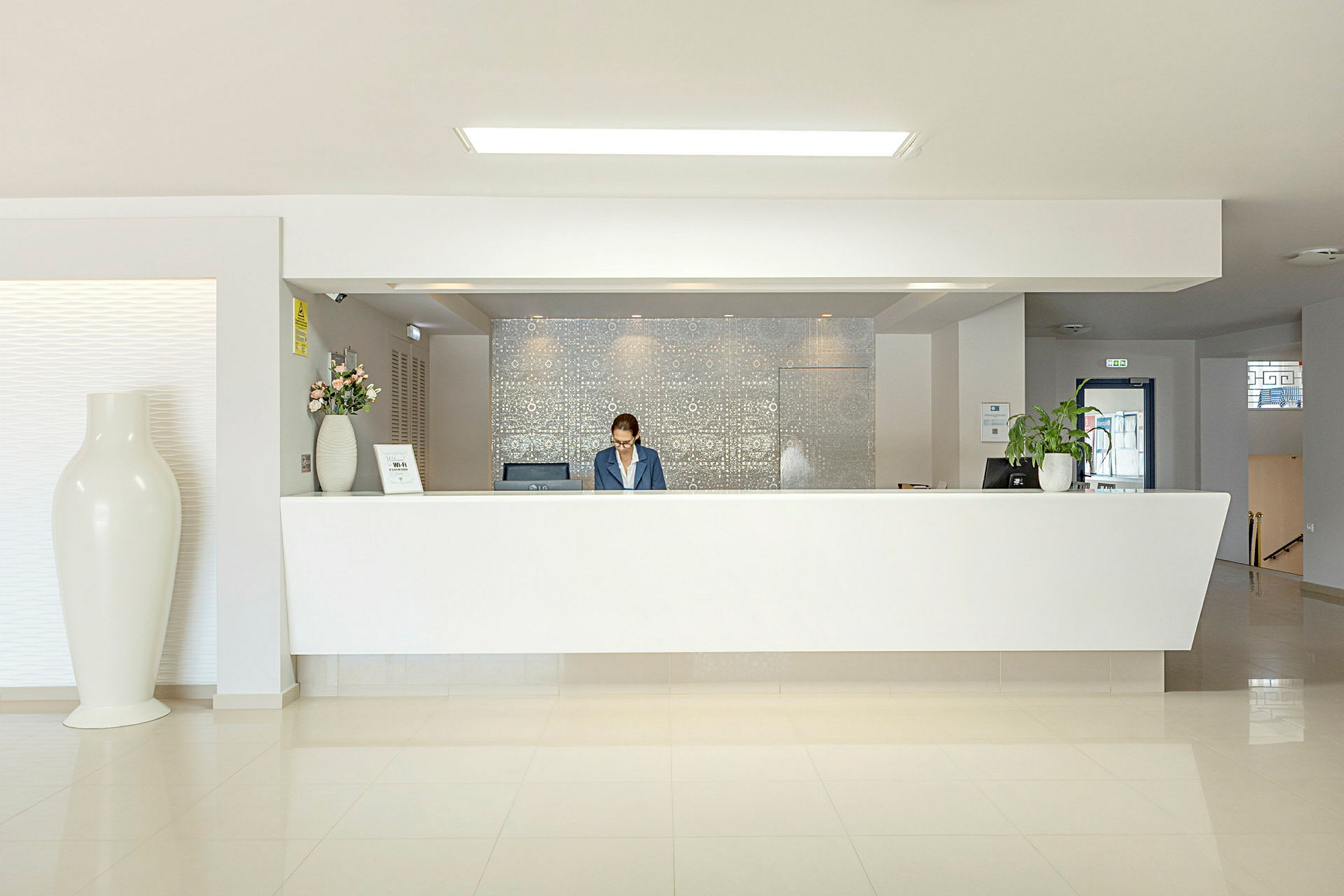 Hotellreception med vit disk och modern inredning. (AI-genererad text)