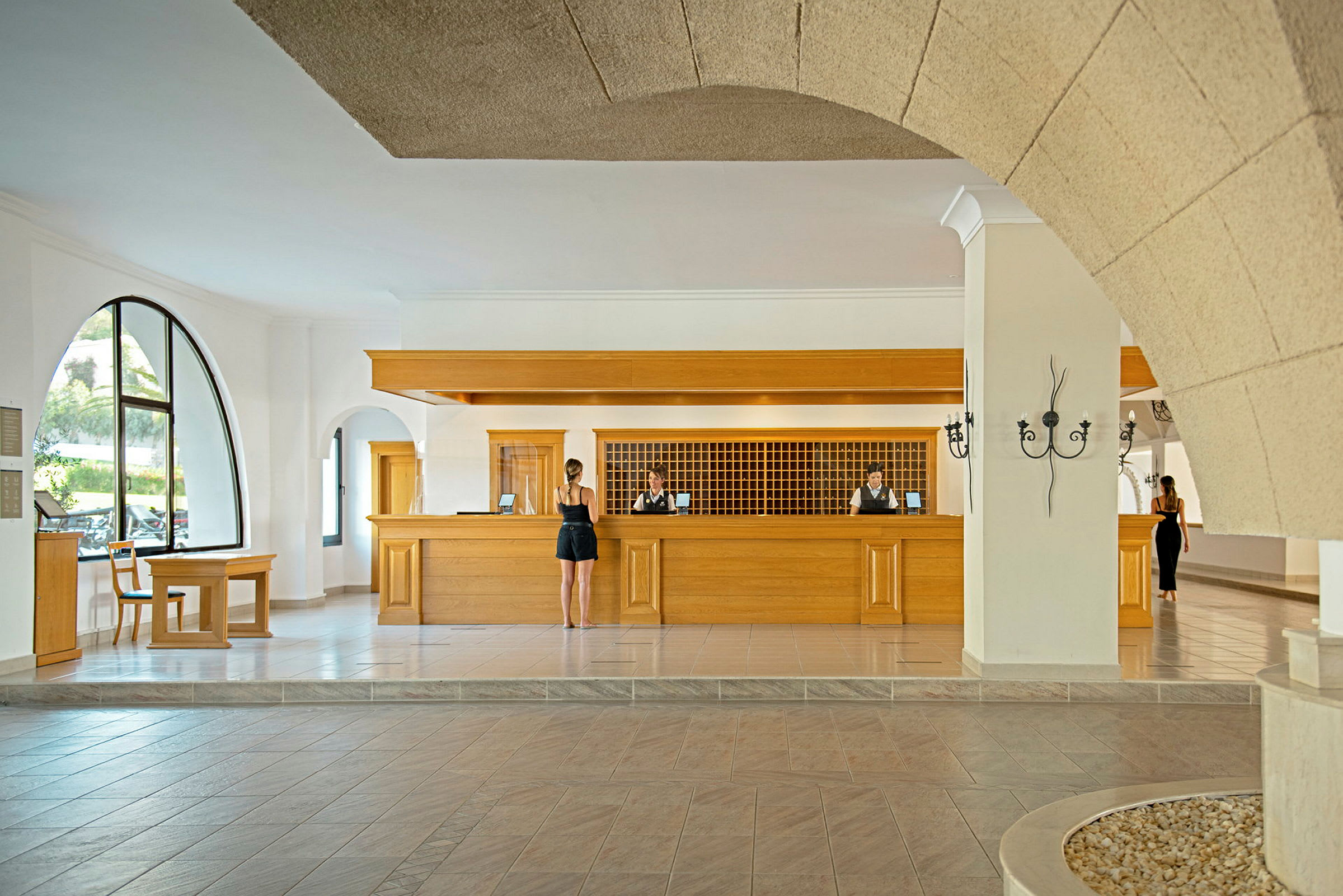 Hotellreception med träpaneler och personal bakom disken. (AI-genererad text)