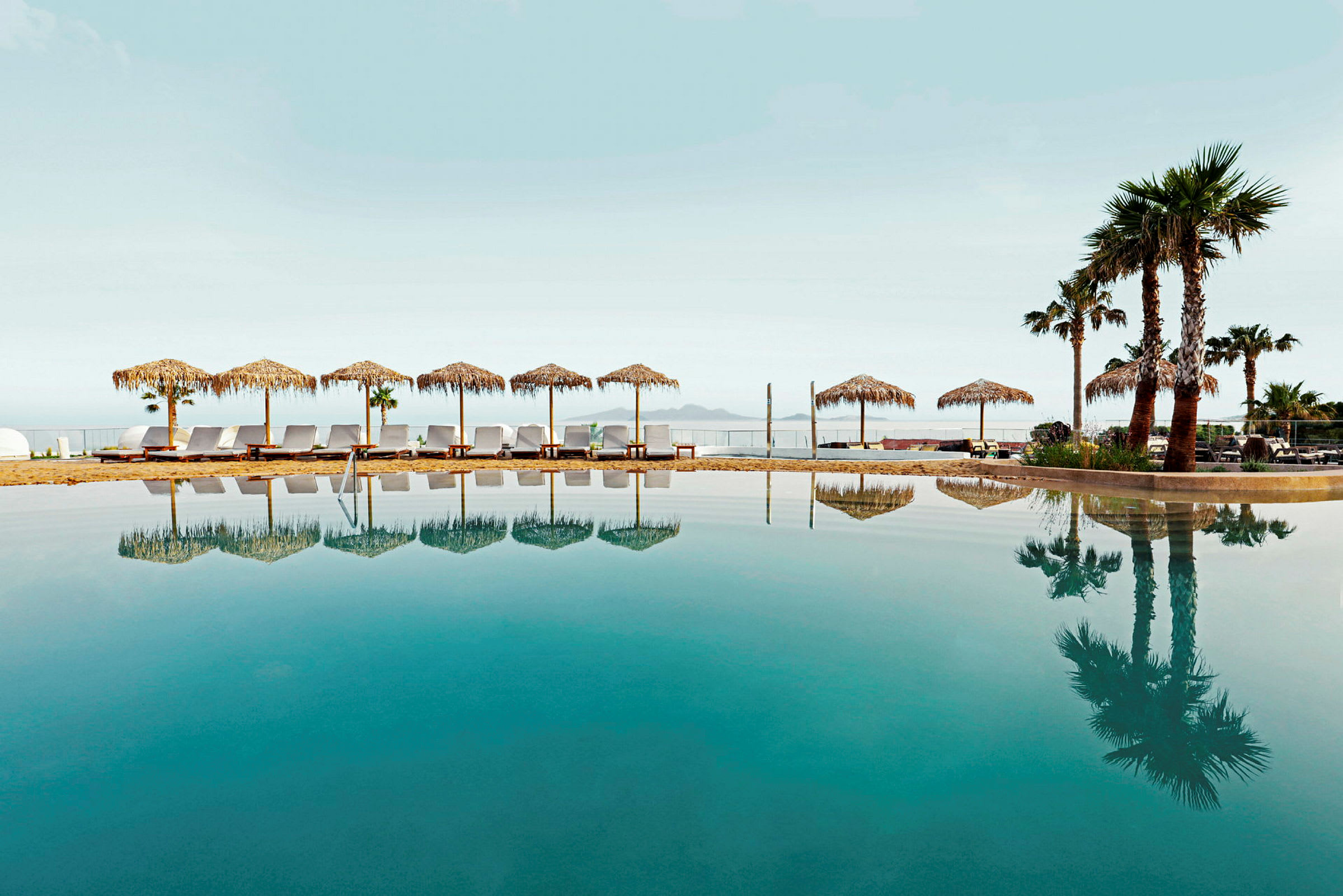 Infinitypool med solstolar och parasoller i bakgrunden. (AI-genererad text)