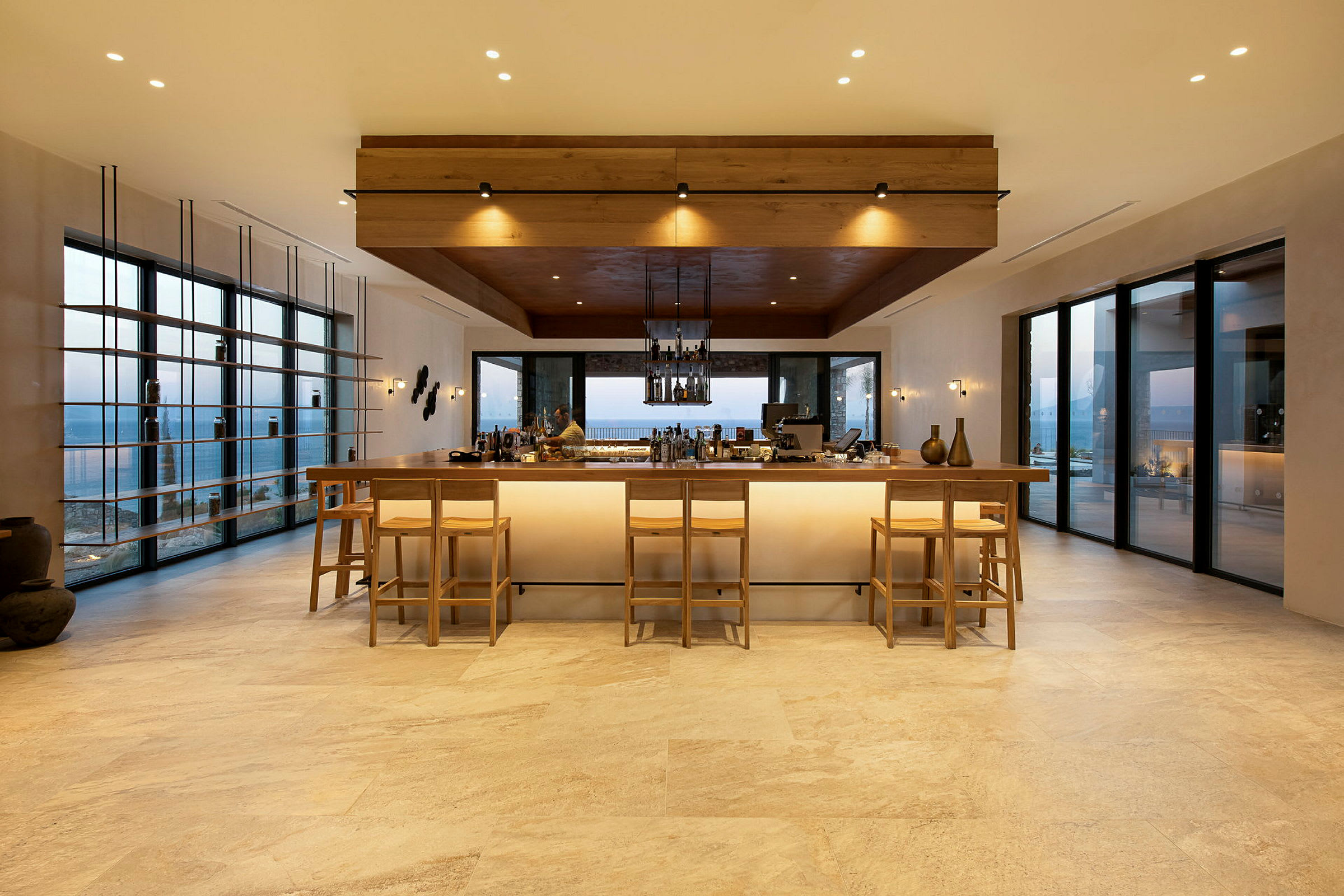 En modern bar med höga stolar framför ett upplyst barmöblemang. (AI-genererad text)