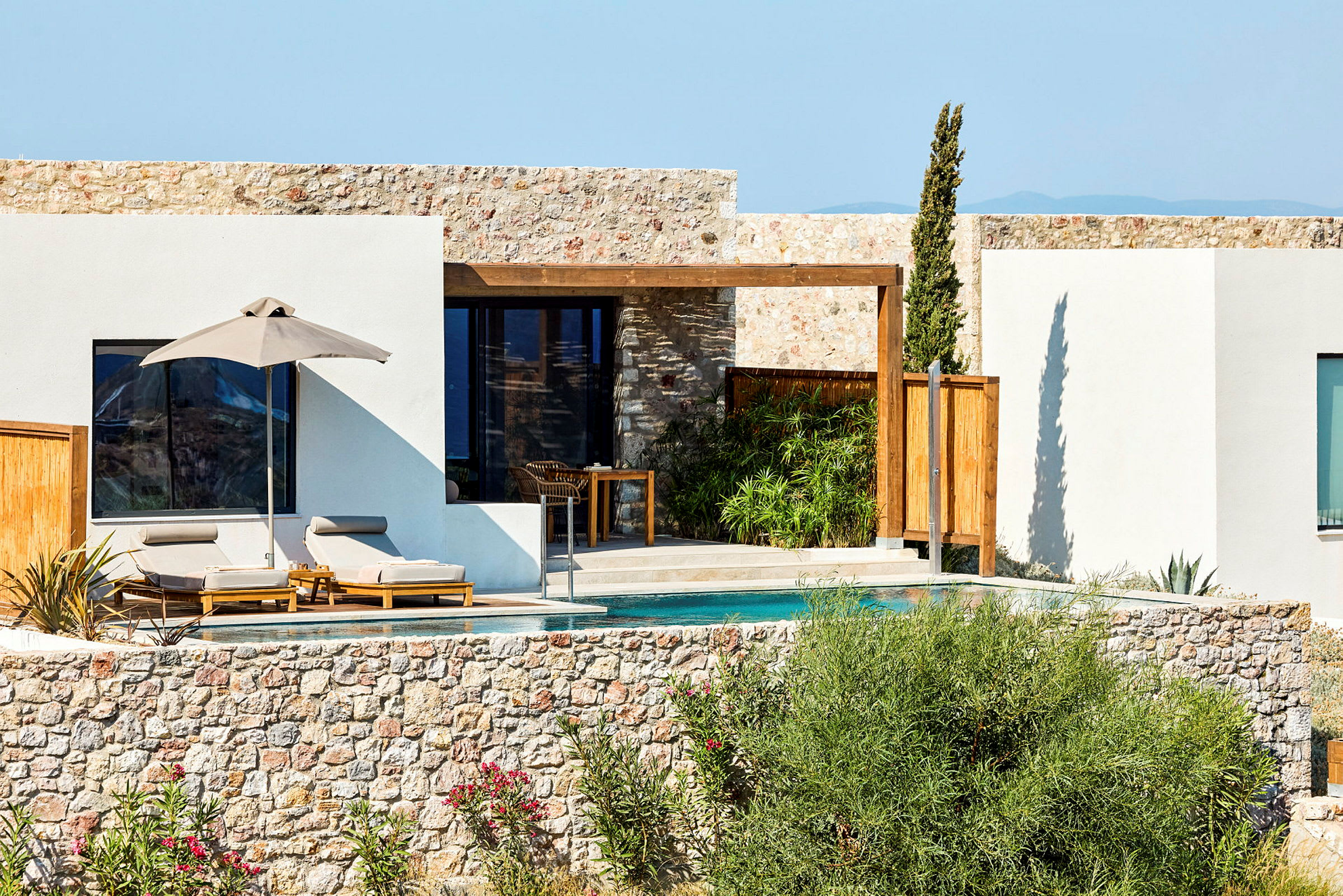 Bild av en solig villa med en privat pool och solstolar, omgivet av natur. (AI-genererad text)