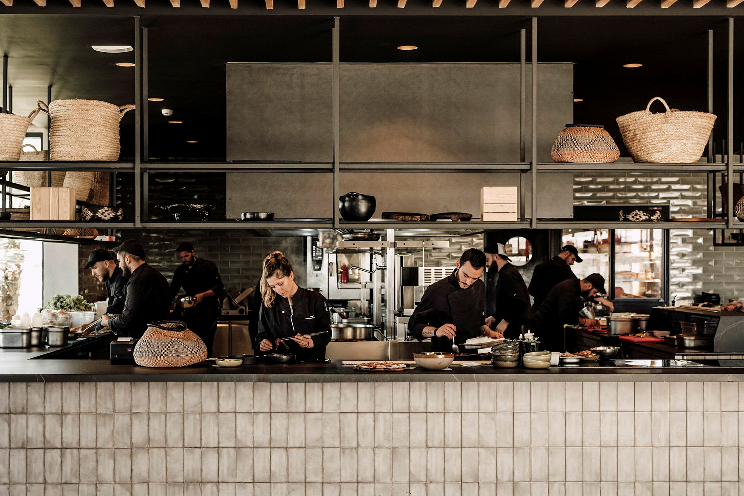 En restaurangköksinteriör med kockar som förbereder mat. (AI-genererad text)