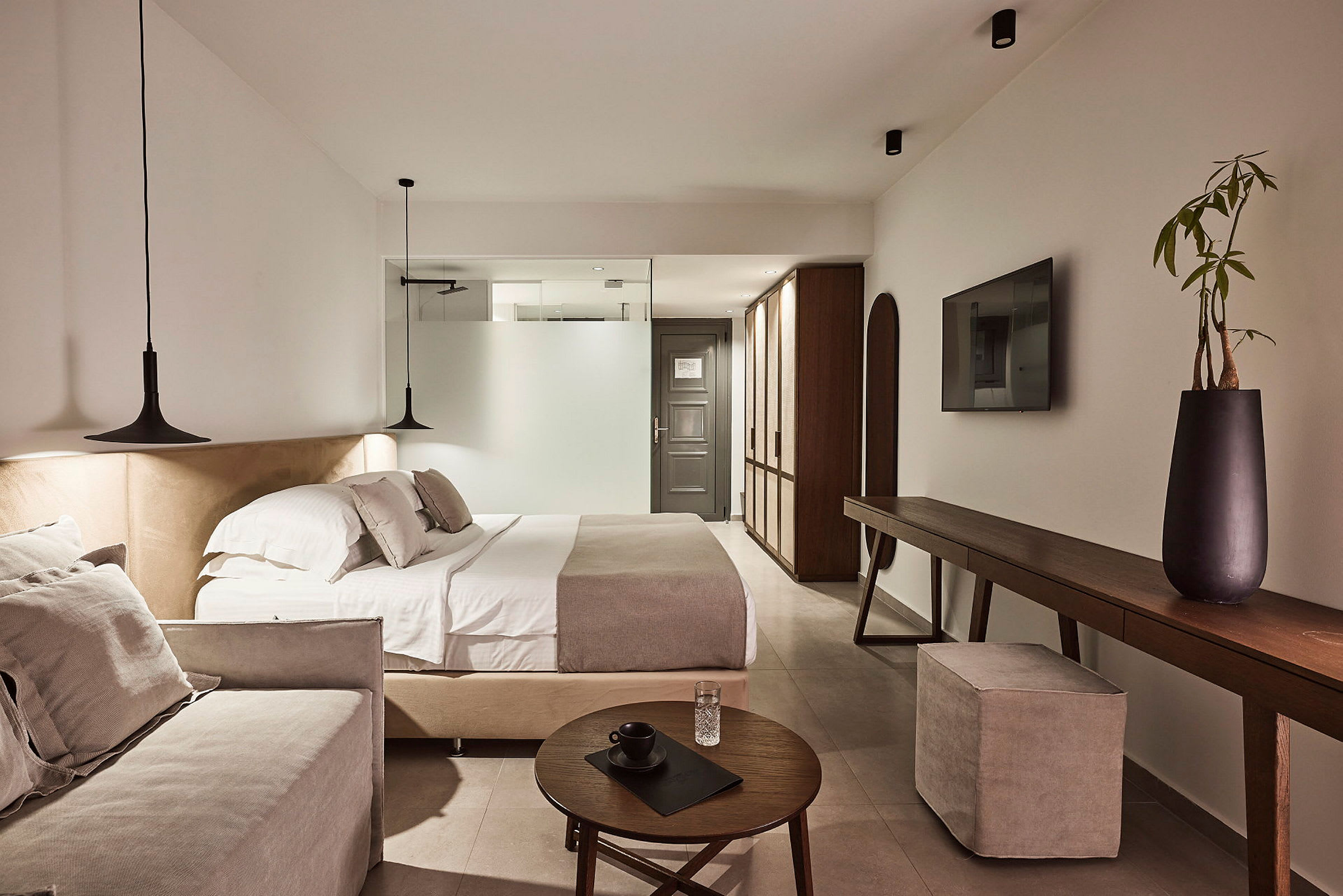Ett modernt hotellrum med dubbelsäng, soffa och elegant inredning. (AI-genererad text)